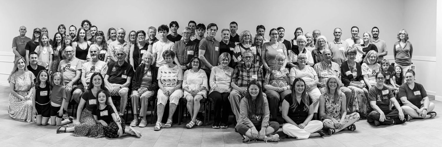 Black and white group photo of a large gathering of people posing together indoors for a formal community or organization portrait.