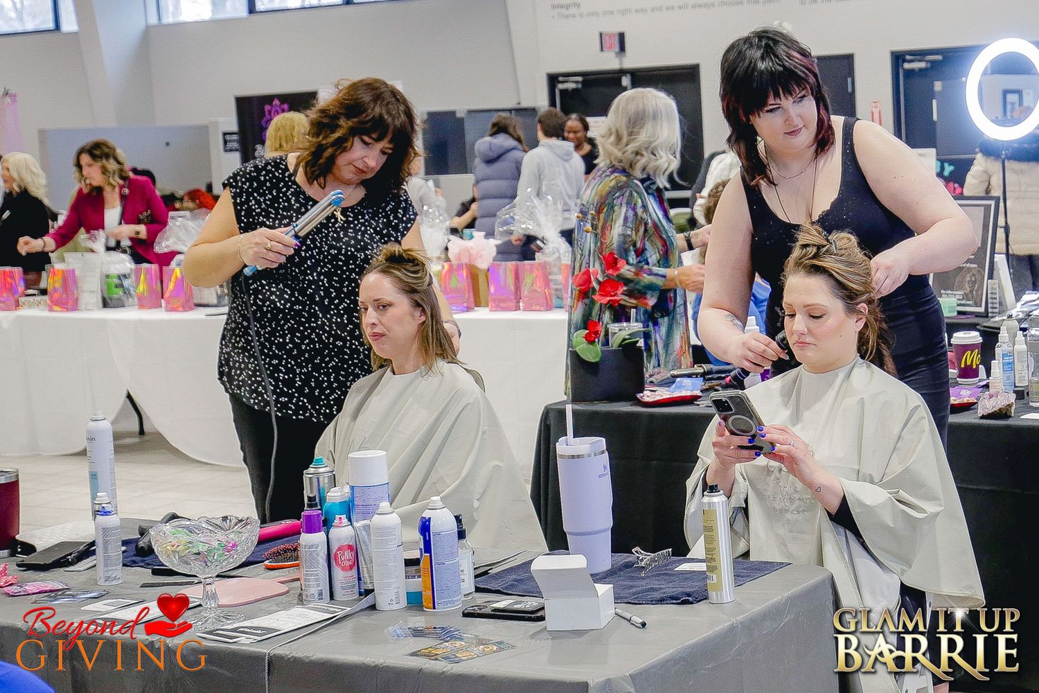 Professional hair stylist focused on styling a guest's hair during a high energy community fundraiser event in Barrie.