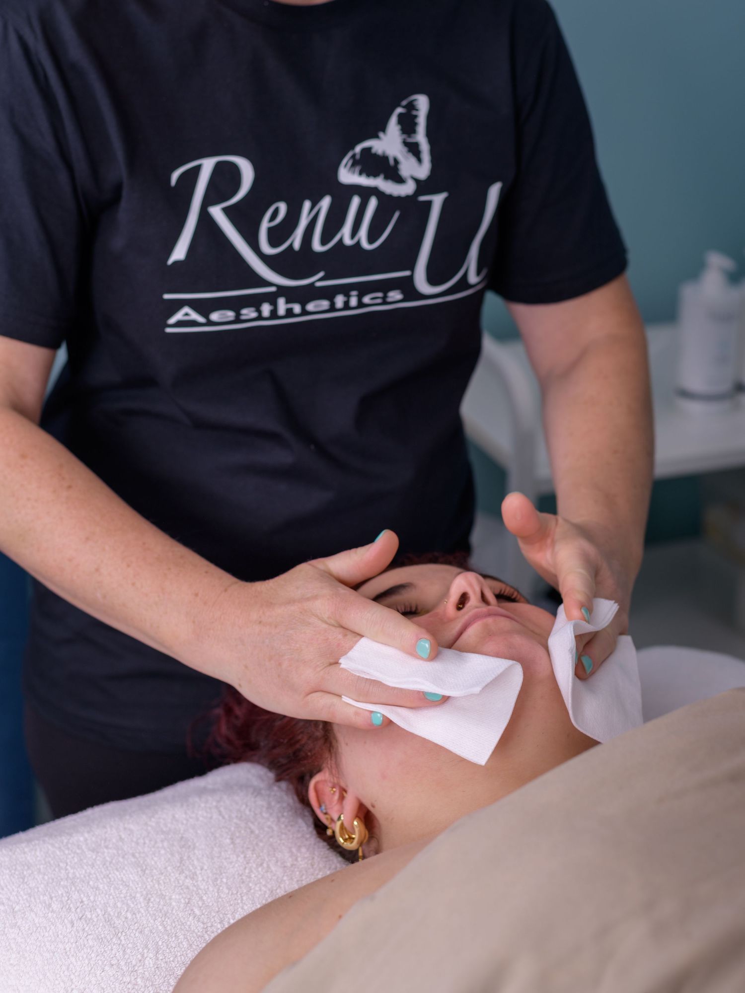 Renu U Aesthetics esthetician performing a professional facial treatment on a client at a beauty spa.