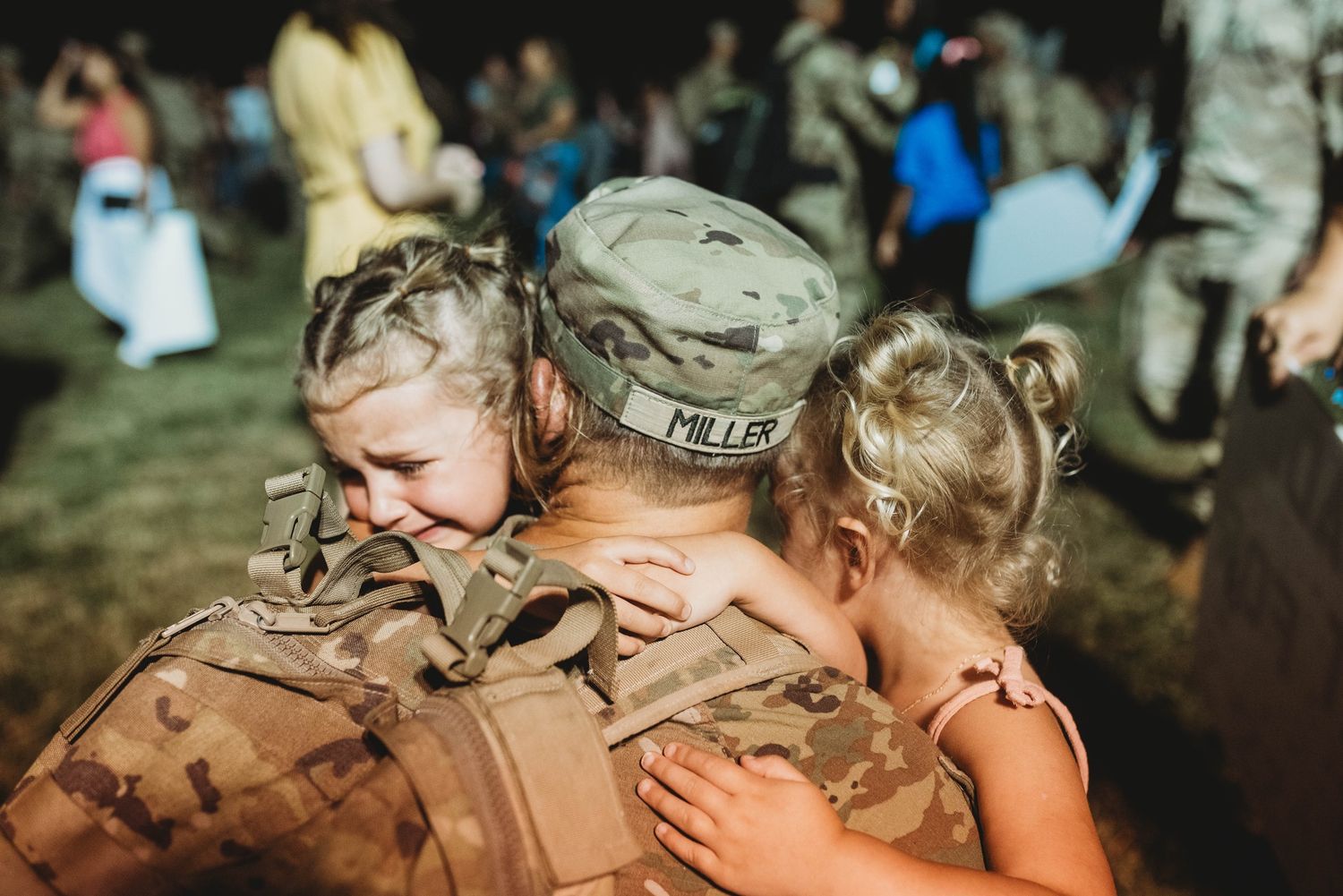 An emotional reunion with a military service member in camouflage uniform.