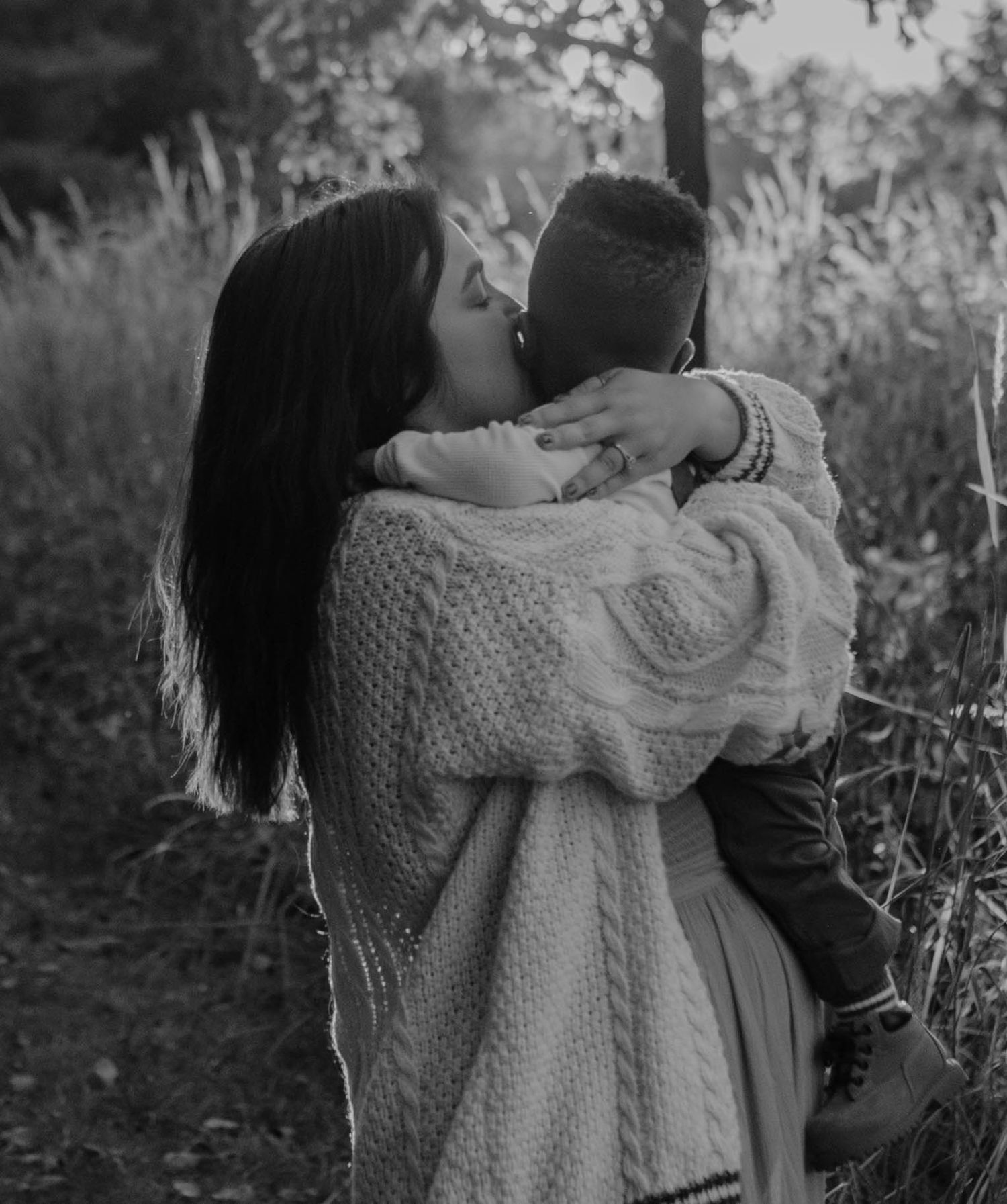 A couple embraces in a series of intimate black and white photos outdoors.