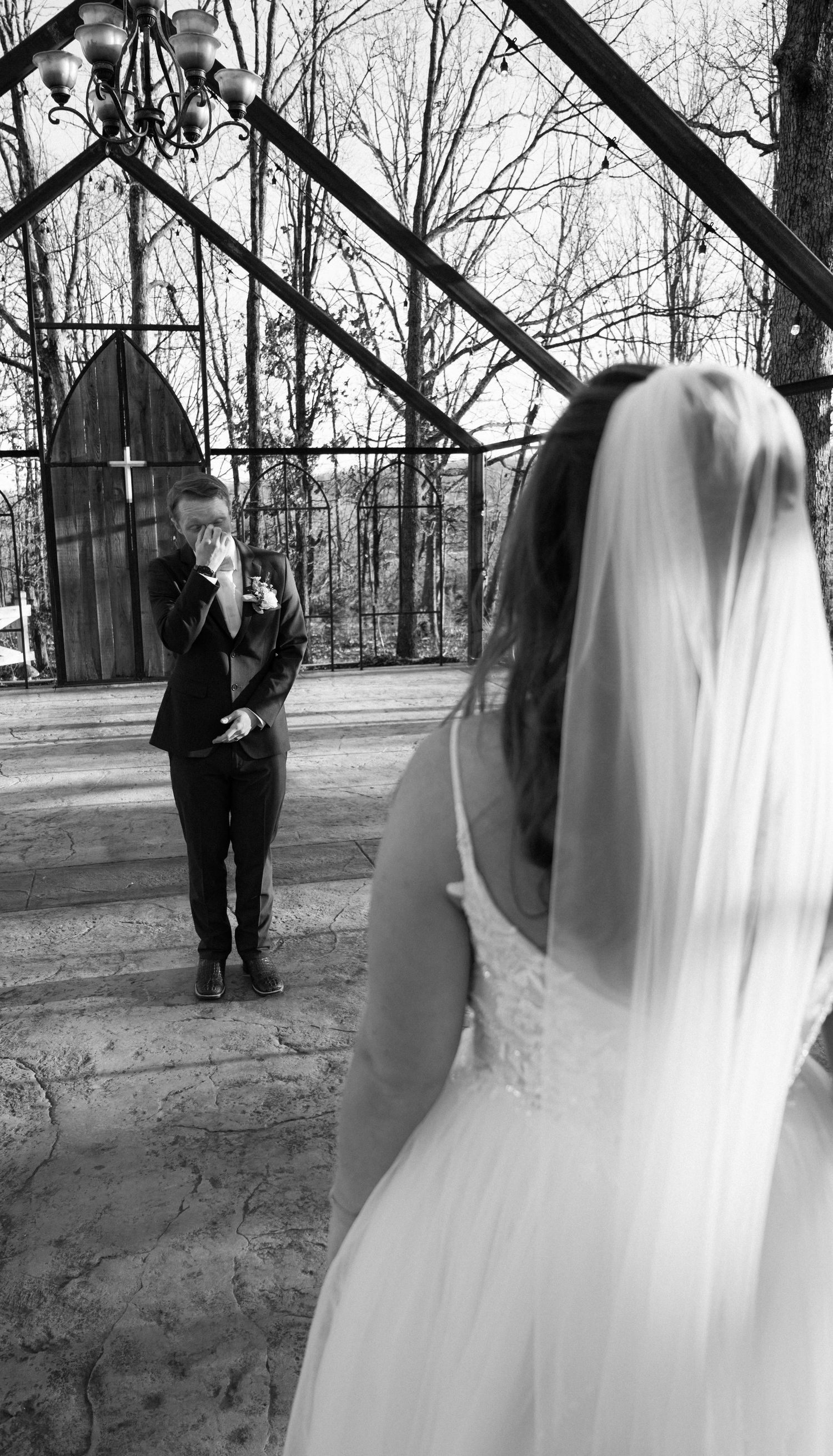 Winter wedding sequence with bride and groom under bare trees in black and white.