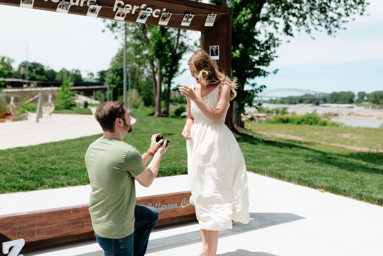 A couple shares a romantic moment during a proposal photoshoot in an outdoor setting.