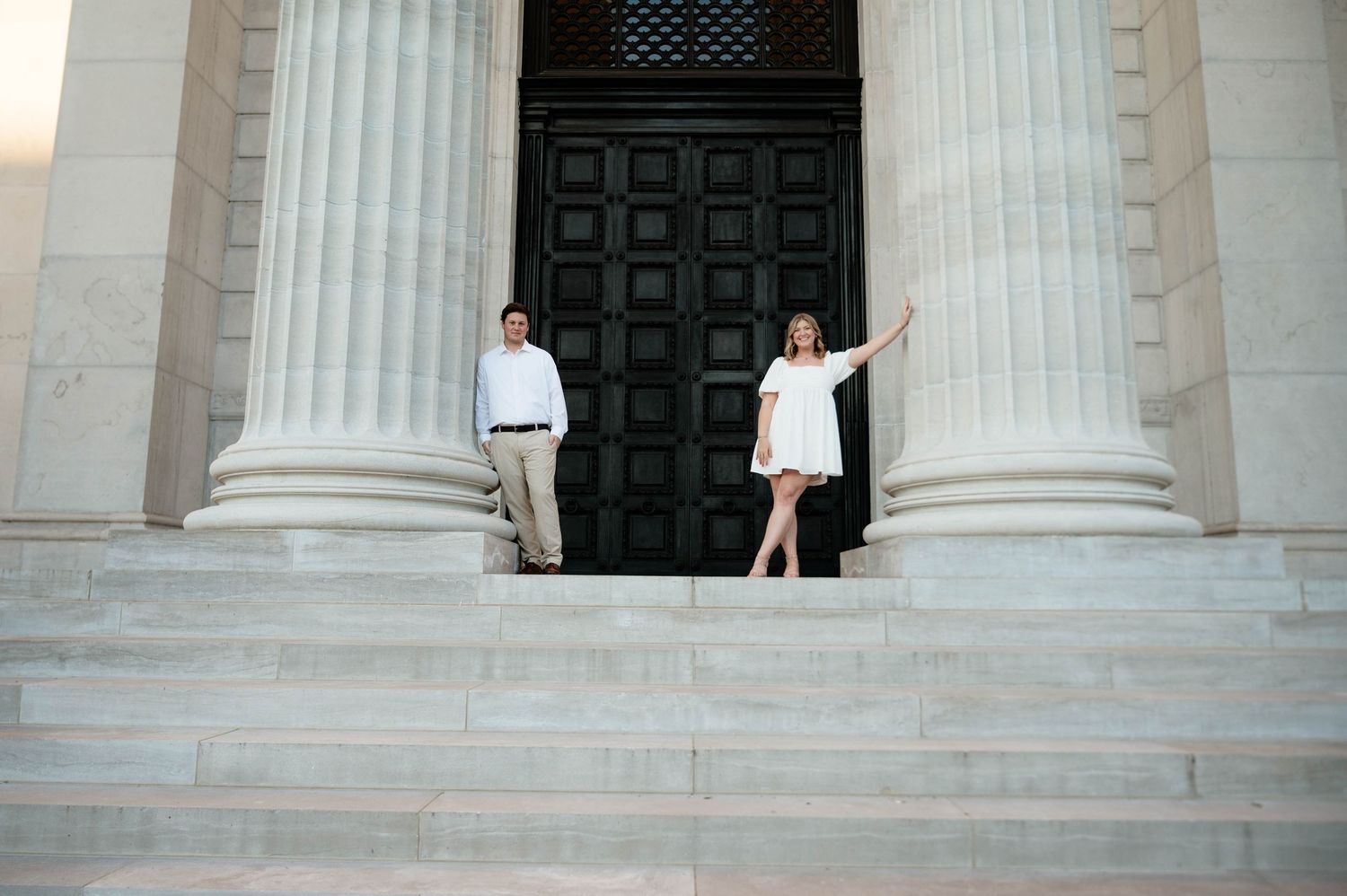 Classic white columns frame a couple on grand stone steps.