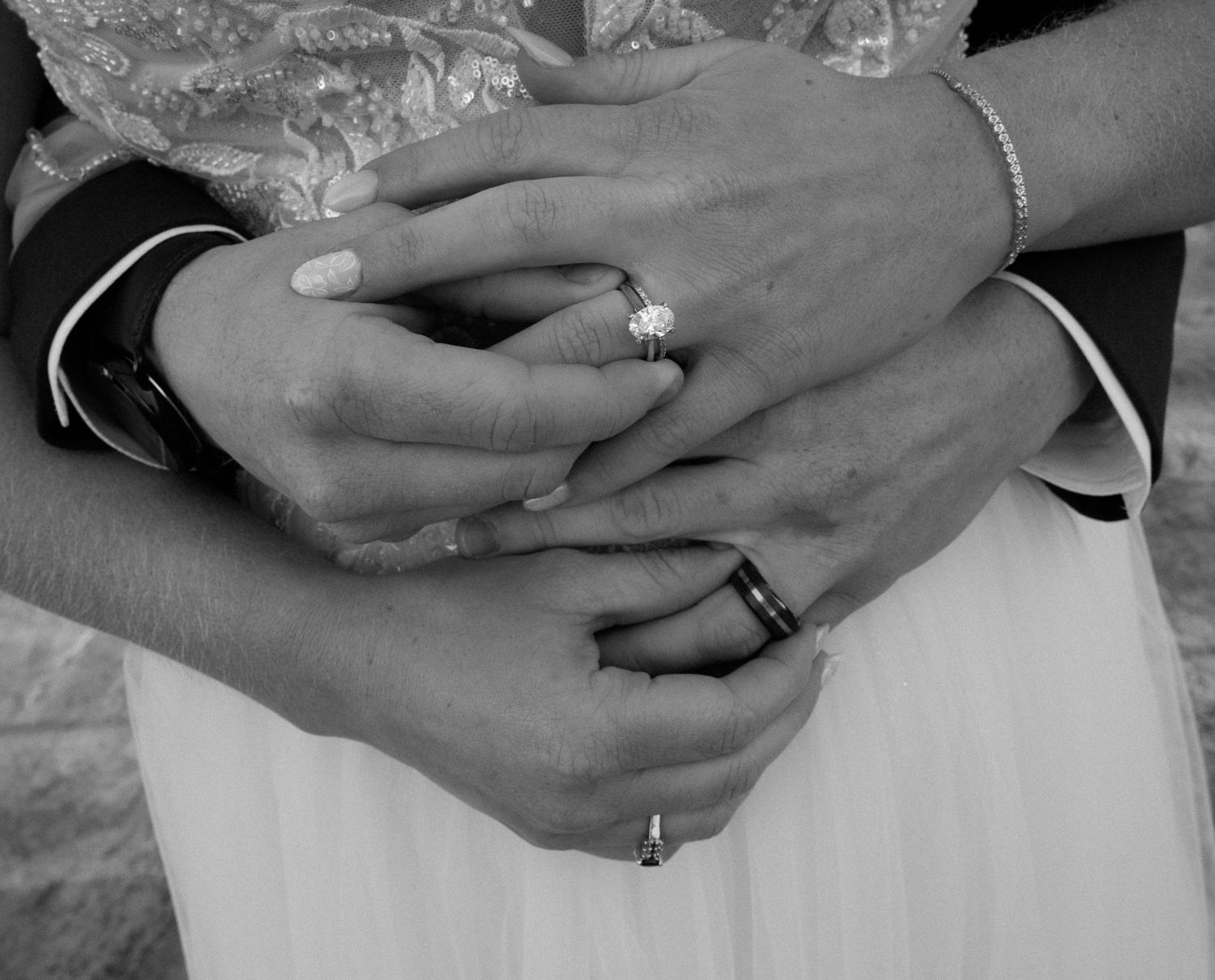 Close-up details of wedding rings and hands showing newly married couple.