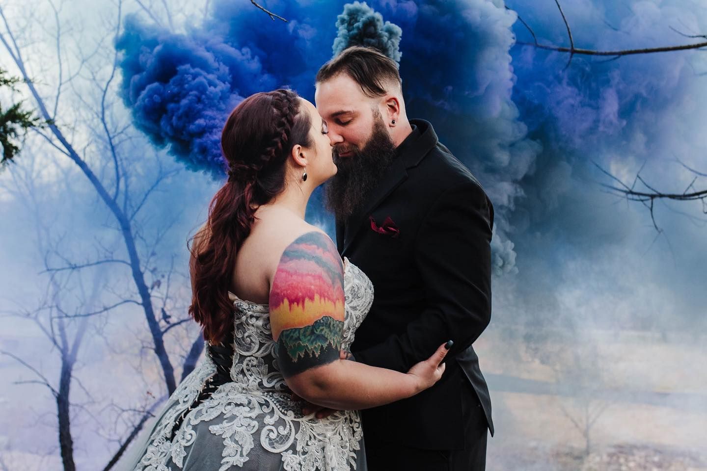 Dramatic wedding portraits with vibrant blue smoke bomb effects.