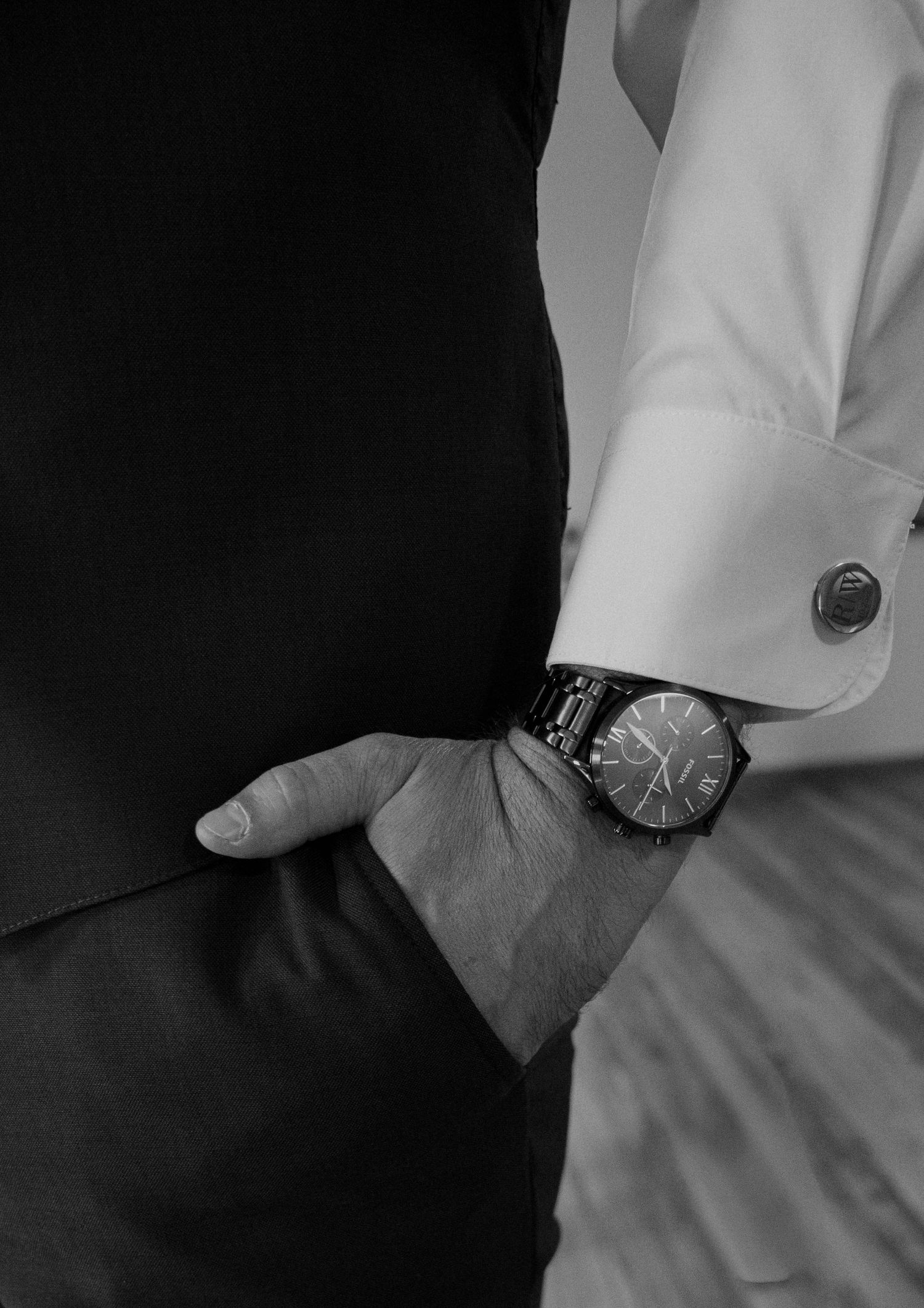 Close-up details of watches and formal attire in black and white.