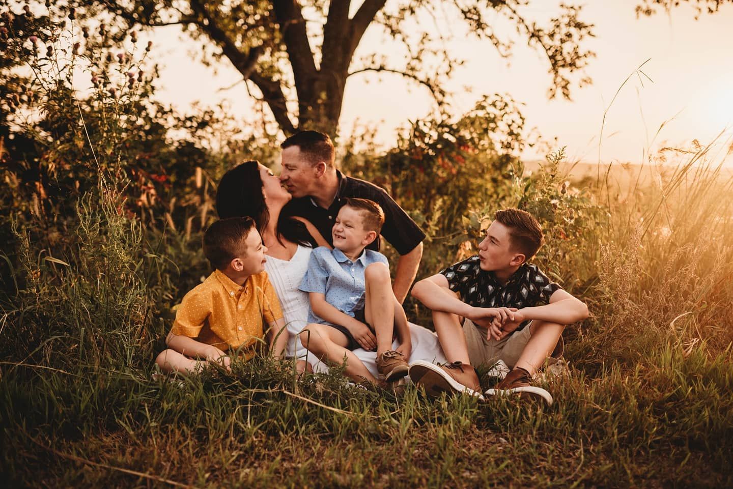 Intimate outdoor photoshoot at sunset with golden light filtering through trees.
