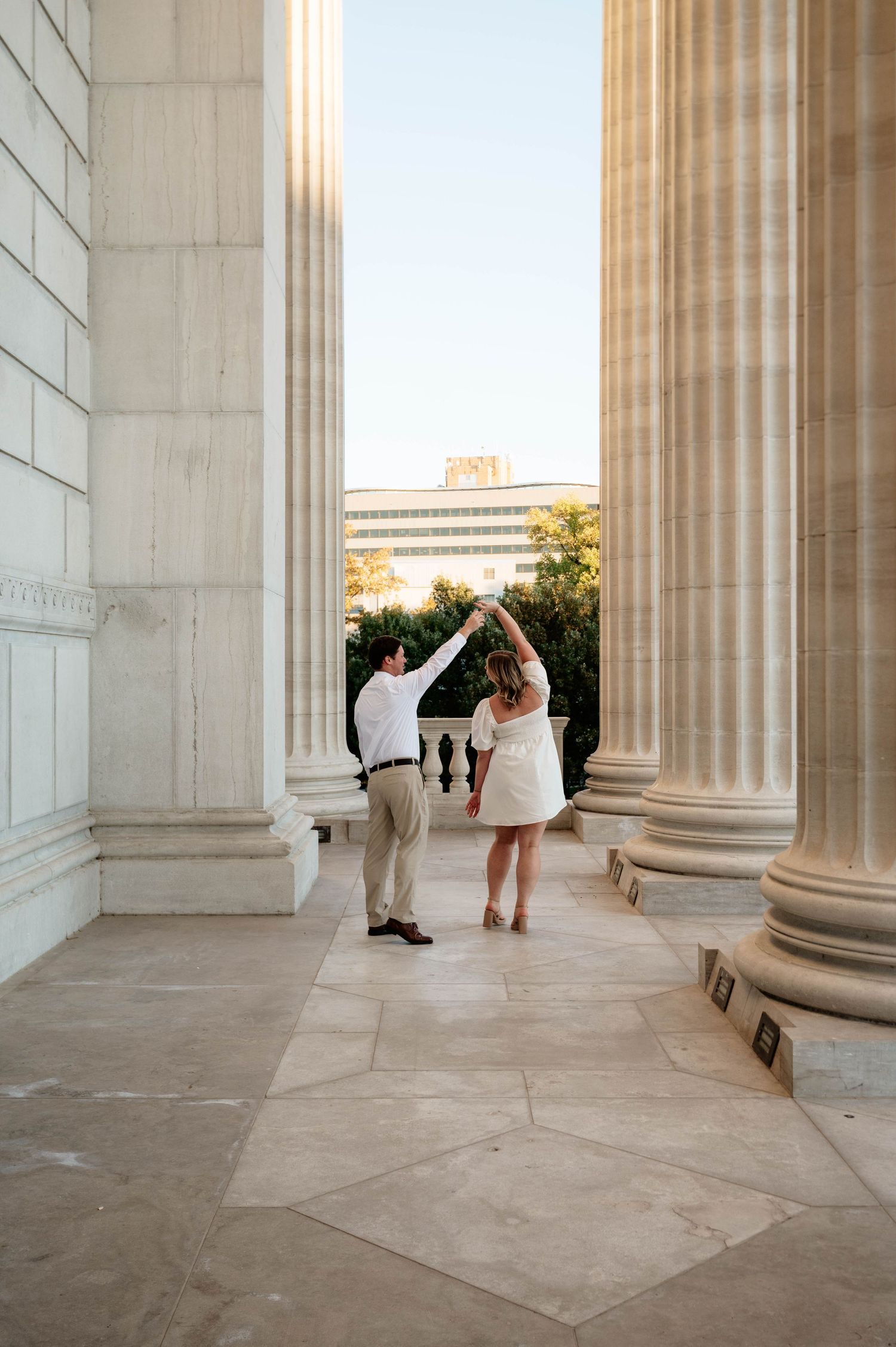 Architectural detail of classical columns with people exploring a grand building entrance.