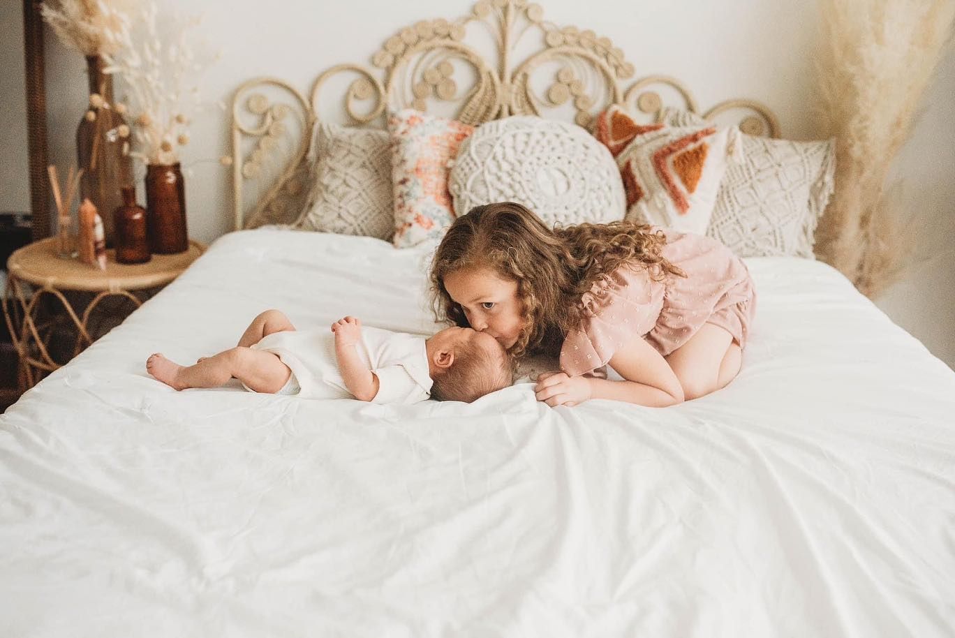 Soft white bedding creates dreamy atmosphere in naturally lit bedroom setting.