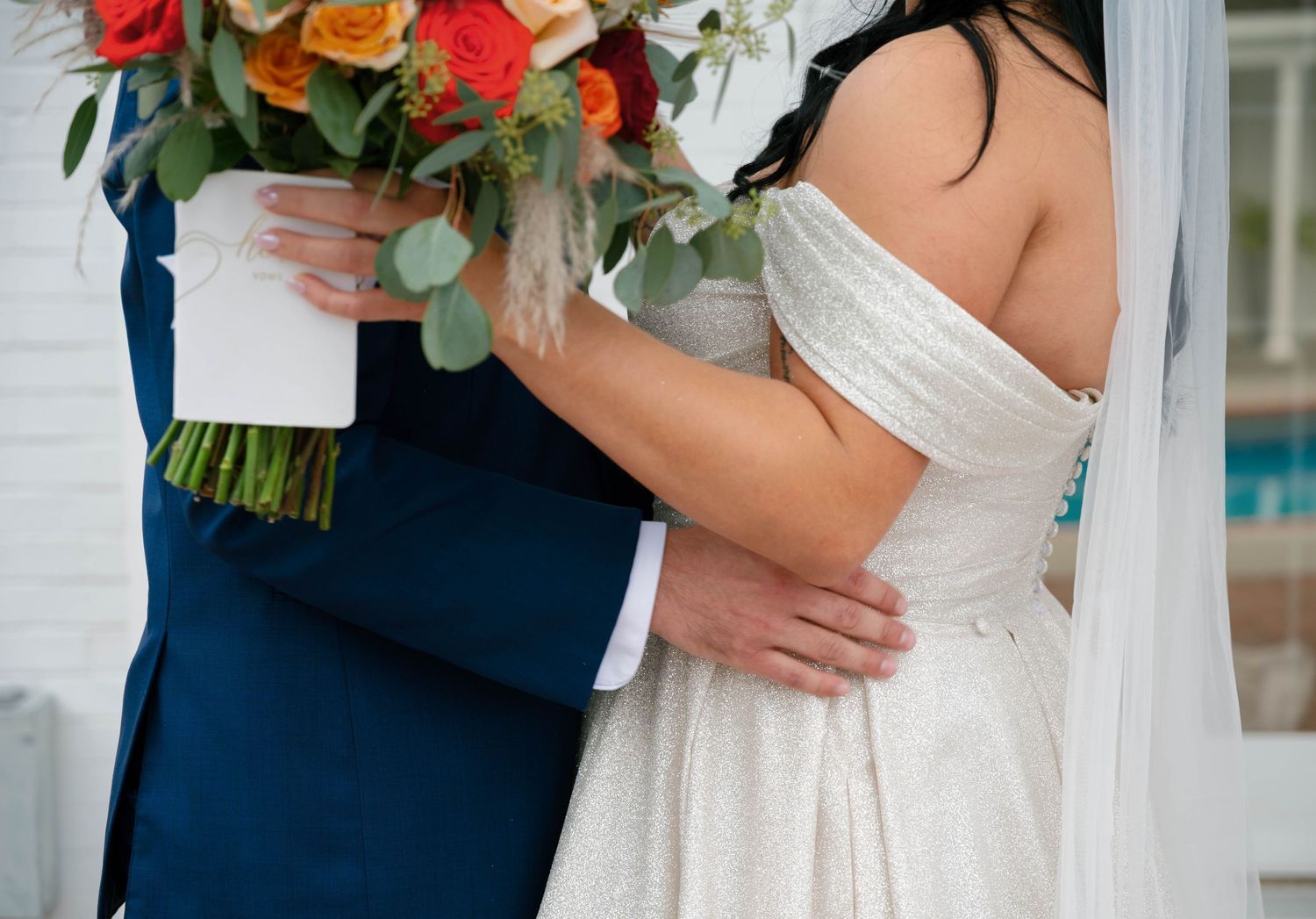 Intimate wedding moment captured with white dress and navy suit.