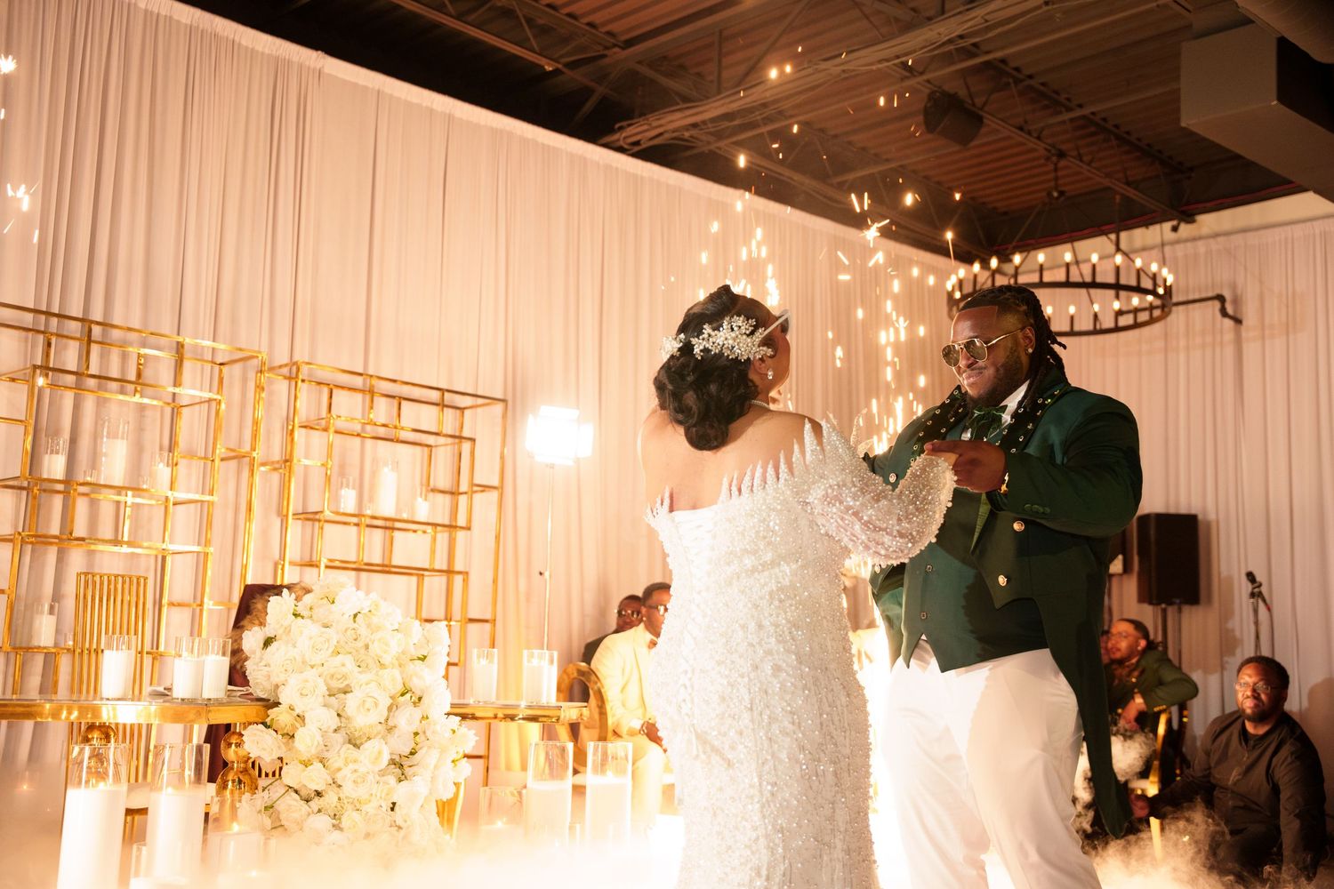 Wedding venue decorated with hanging lights and white fabric draping.