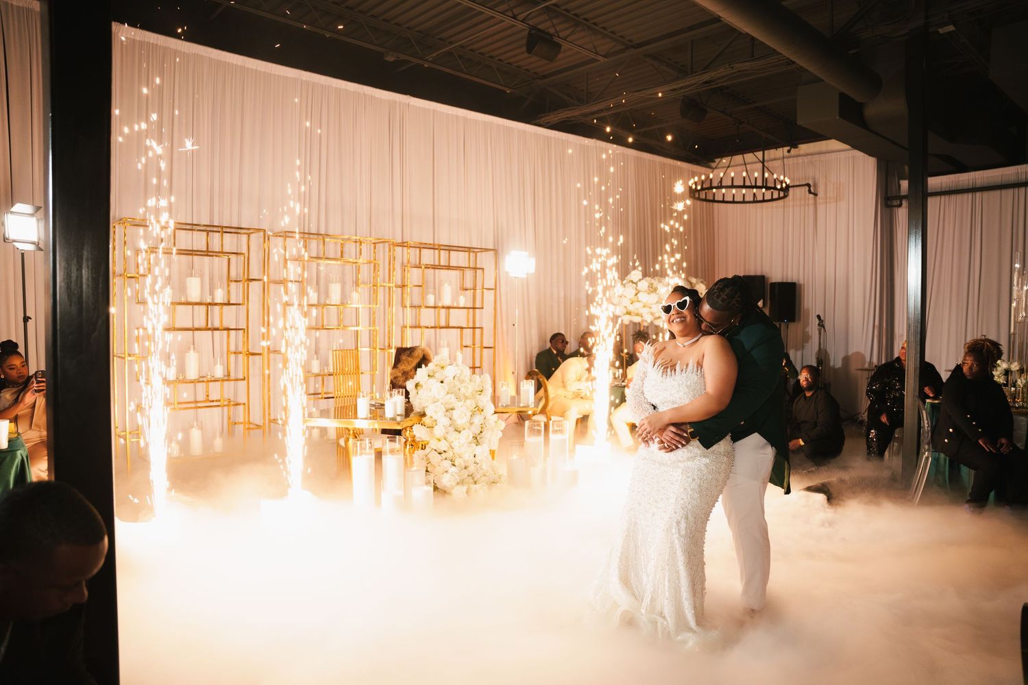 Couple shares first dance surrounded by dry ice fog and sparkling fairy lights at elegant wedding reception.