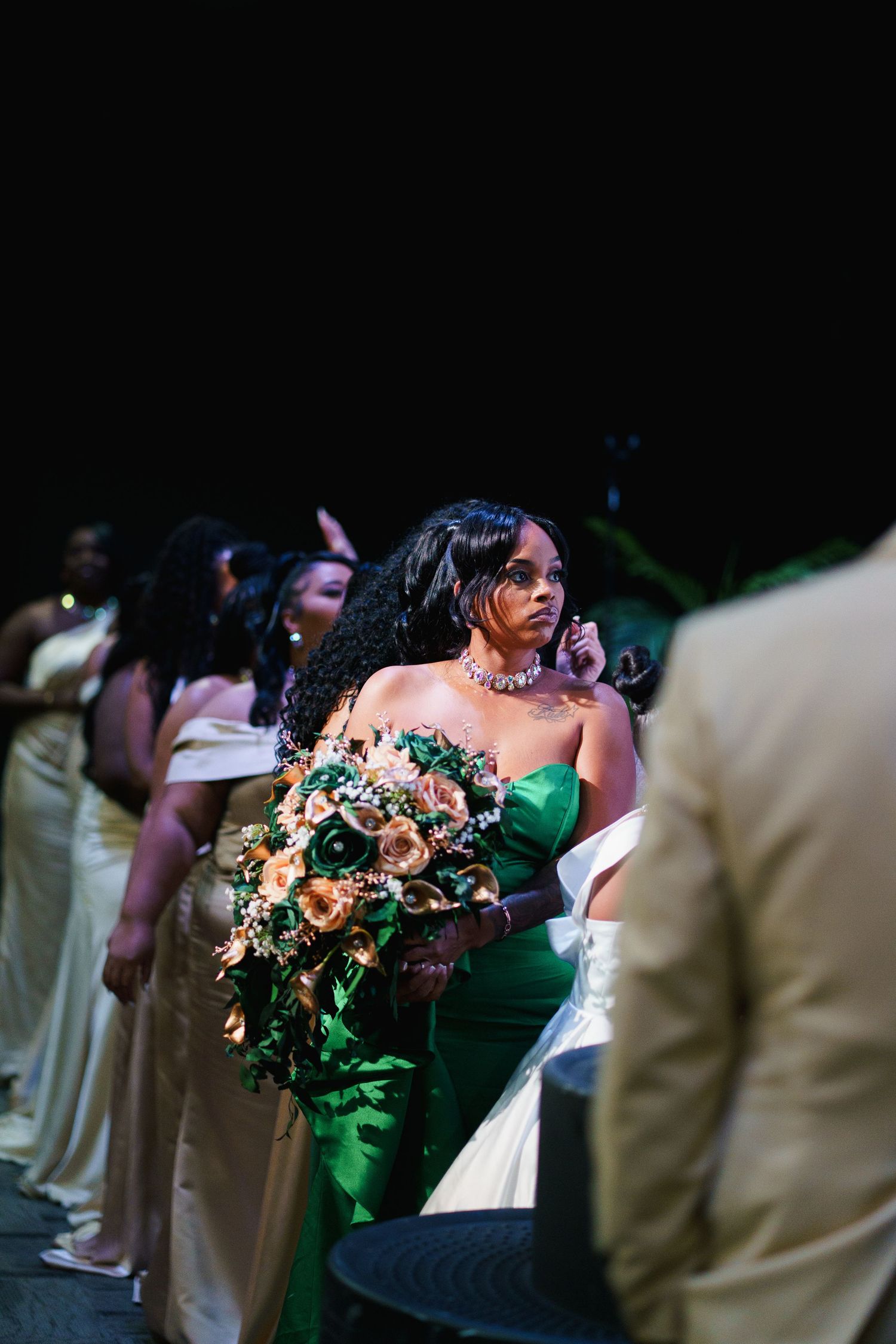 Wedding party members in beige suits and dresses stand together during an elegant celebration ceremony.