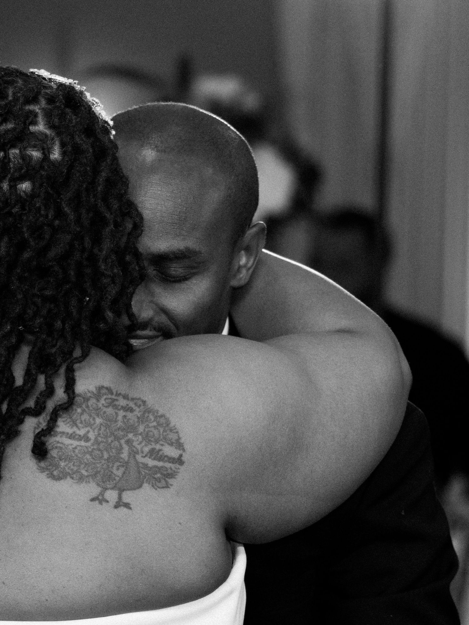 A tender black and white photo capturing an intimate embrace between a couple.