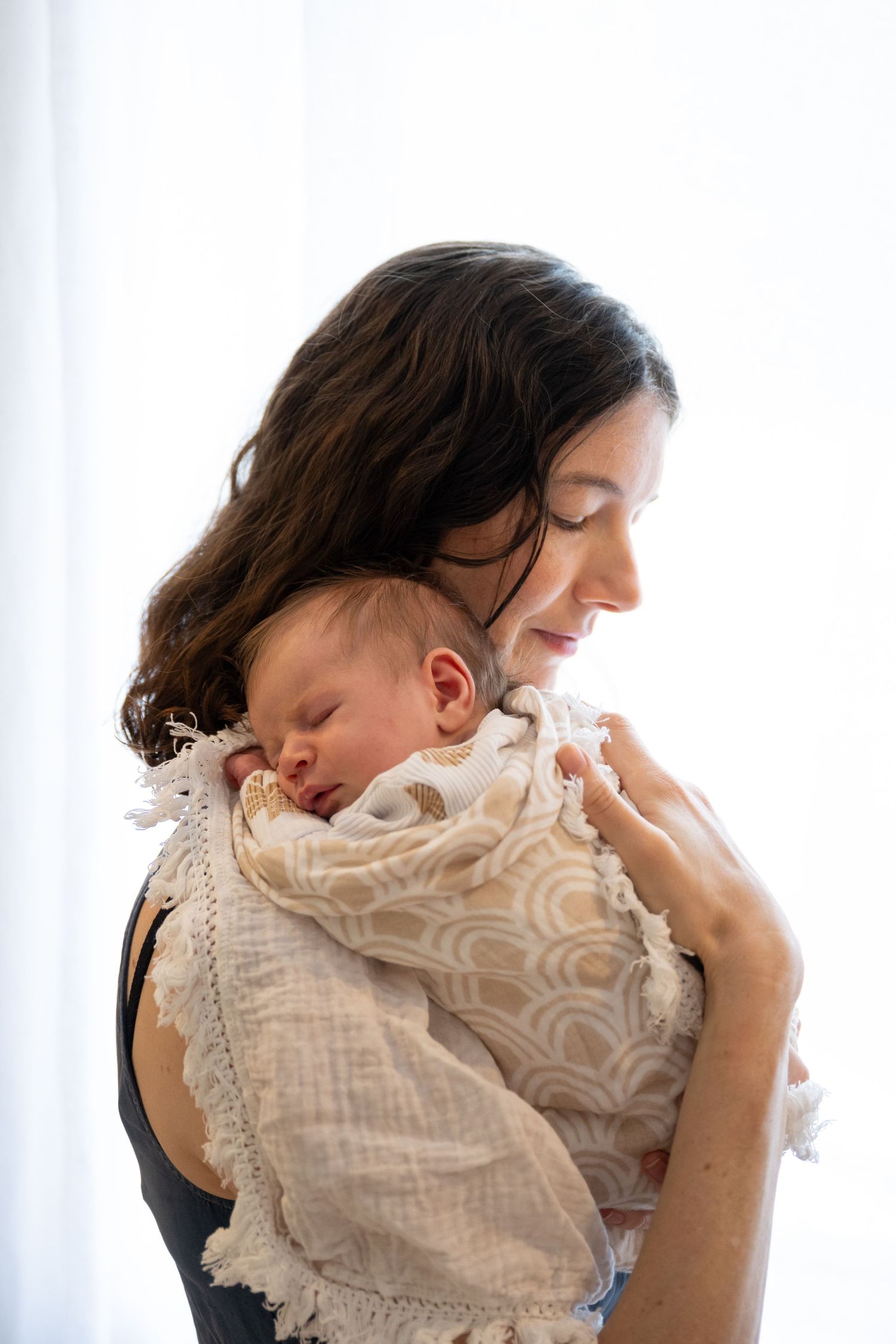 Mother cuddling newborn during studio newborn photography session in Tweed Heads