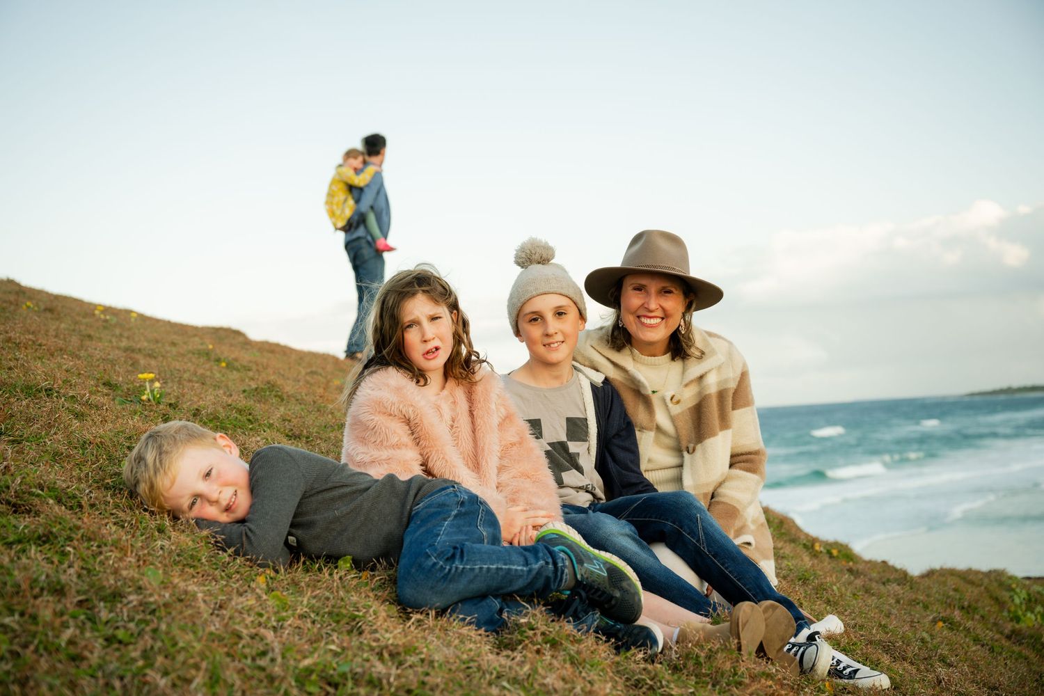 Family enjoying sunset together on cliffs at Cabarita Headland while on holidays.