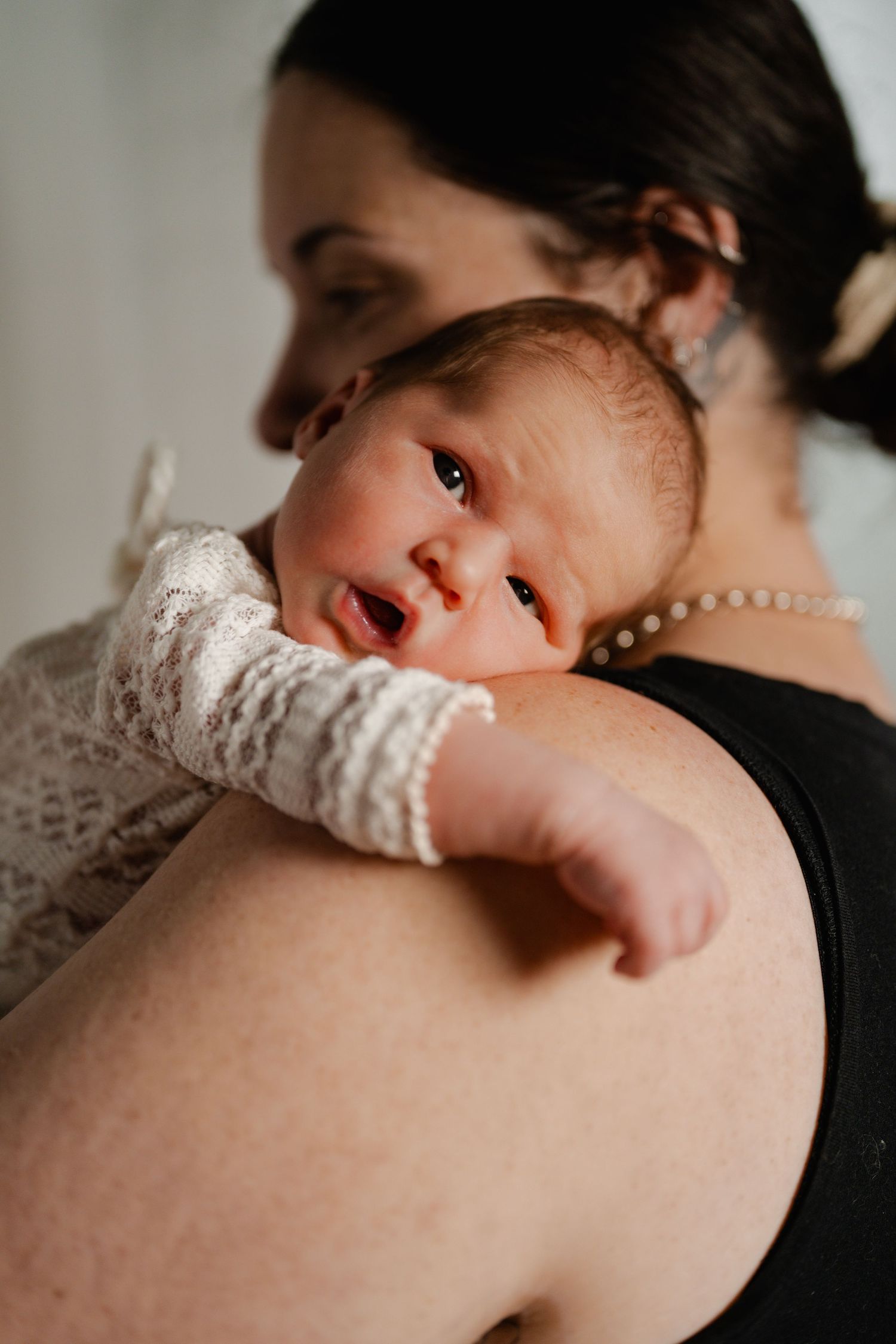 Mother cuddling newborn during studio newborn photography session in Tweed Heads