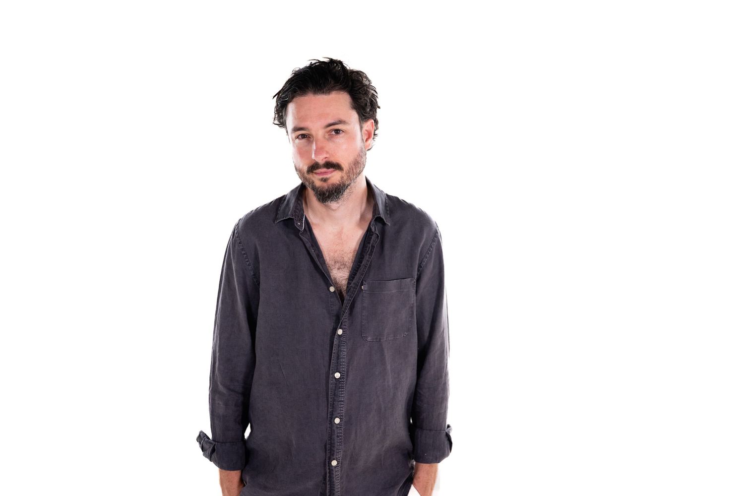 Person in a dark gray button-up shirt shown from different angles against a white background.