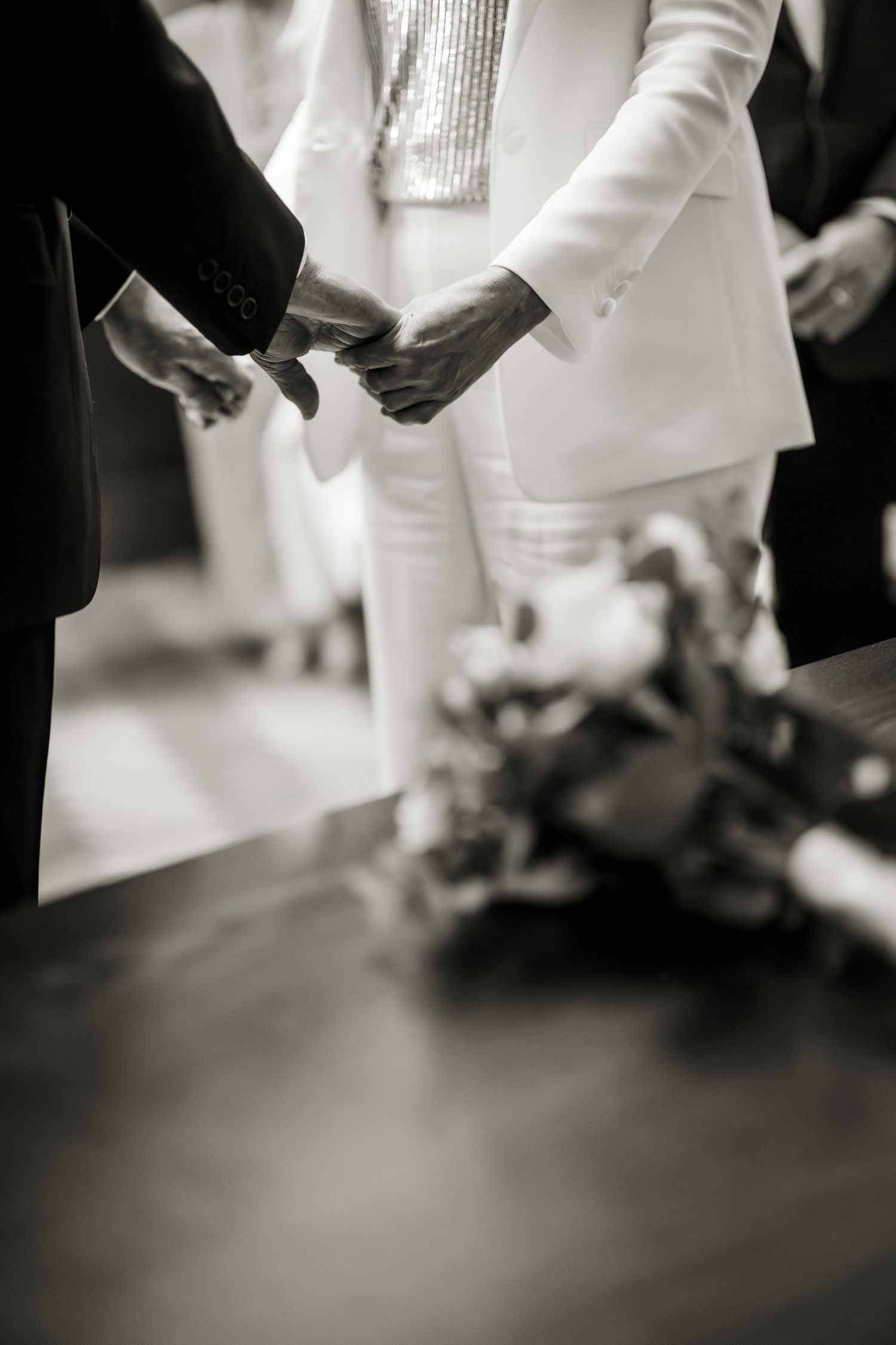 Close up of a bride and groom holding hands during an intimate wedding ceremony at Marylebone town hall.