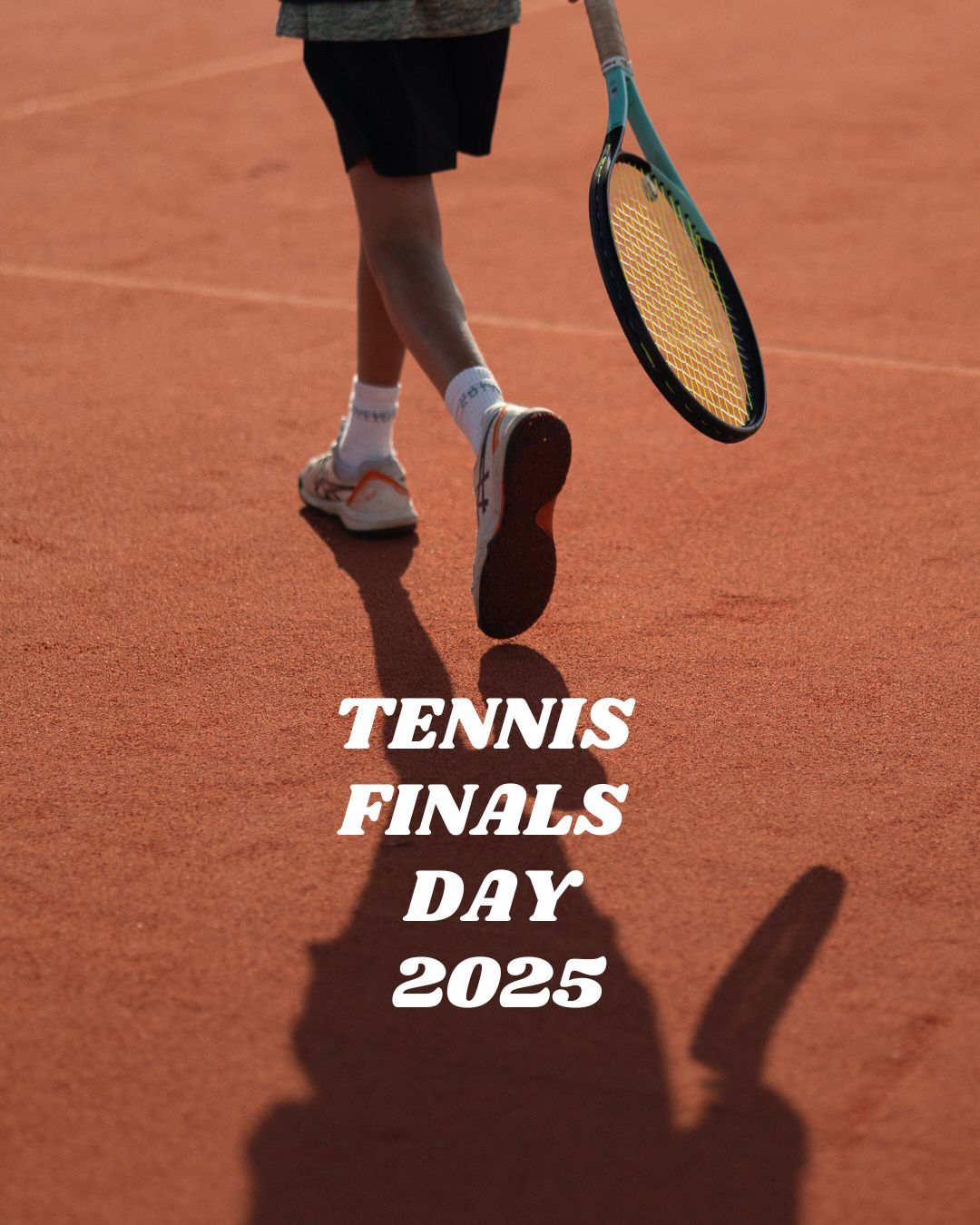 Tennis player walking away, holding his tennis racket, plus his shadow on clay courts.