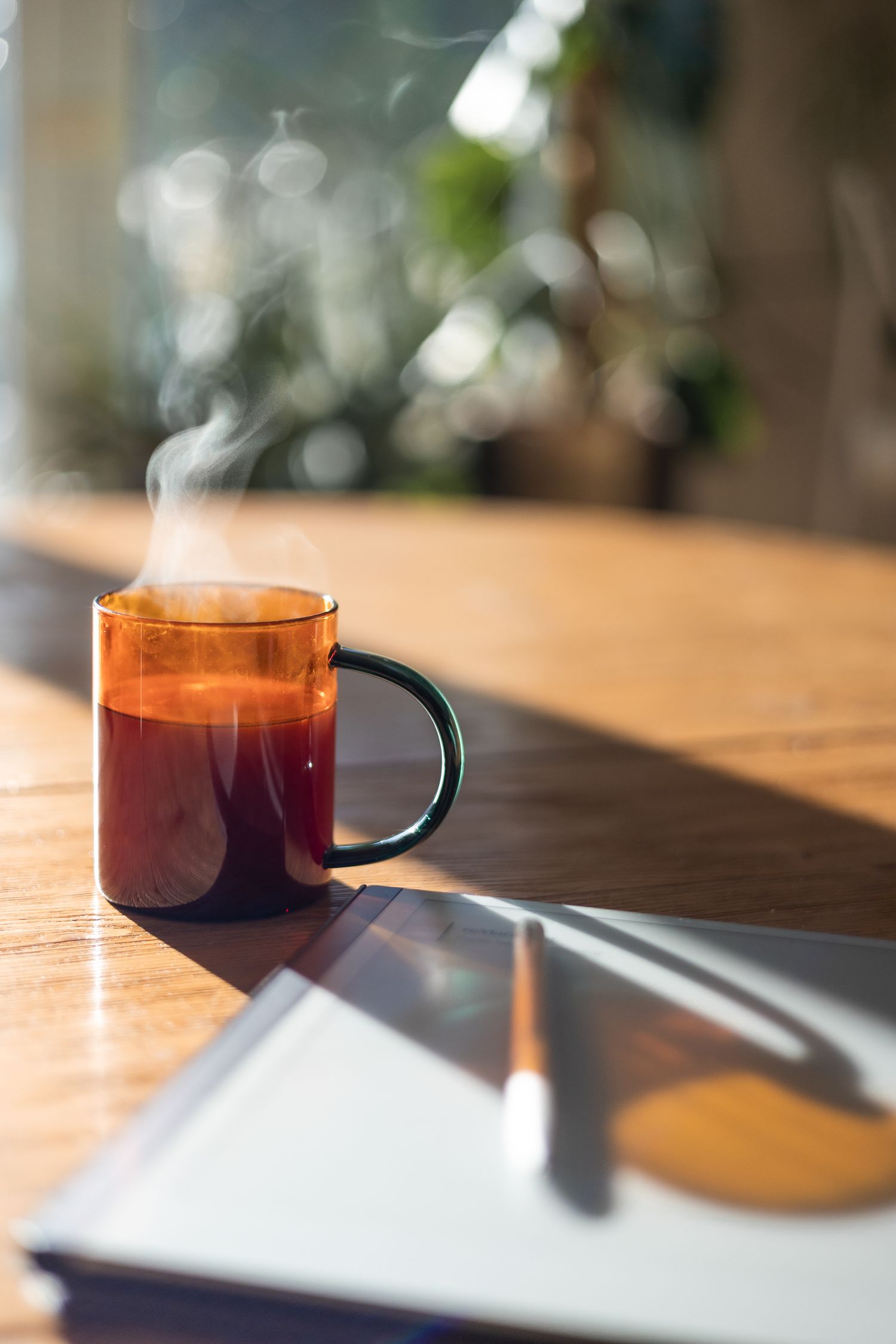 Steaming cup of coffee, and remarkable notepad of a self employed photographer in London