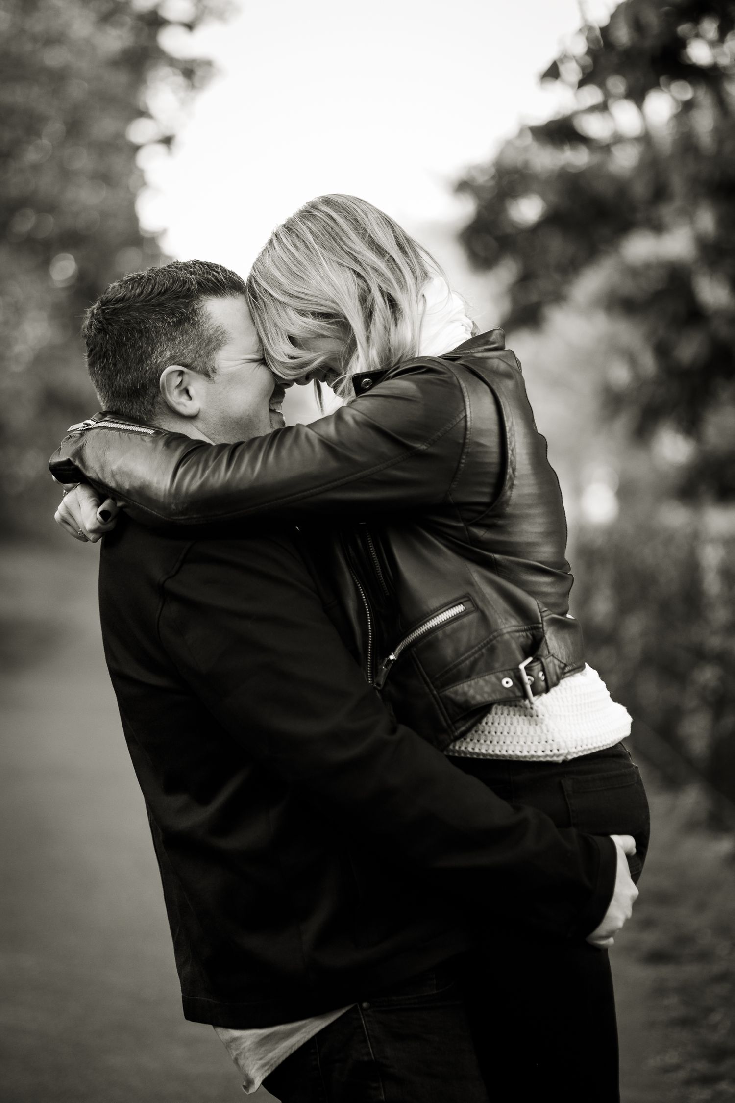 Natural interaction of the couple with their heads together, captured in soft daylight.