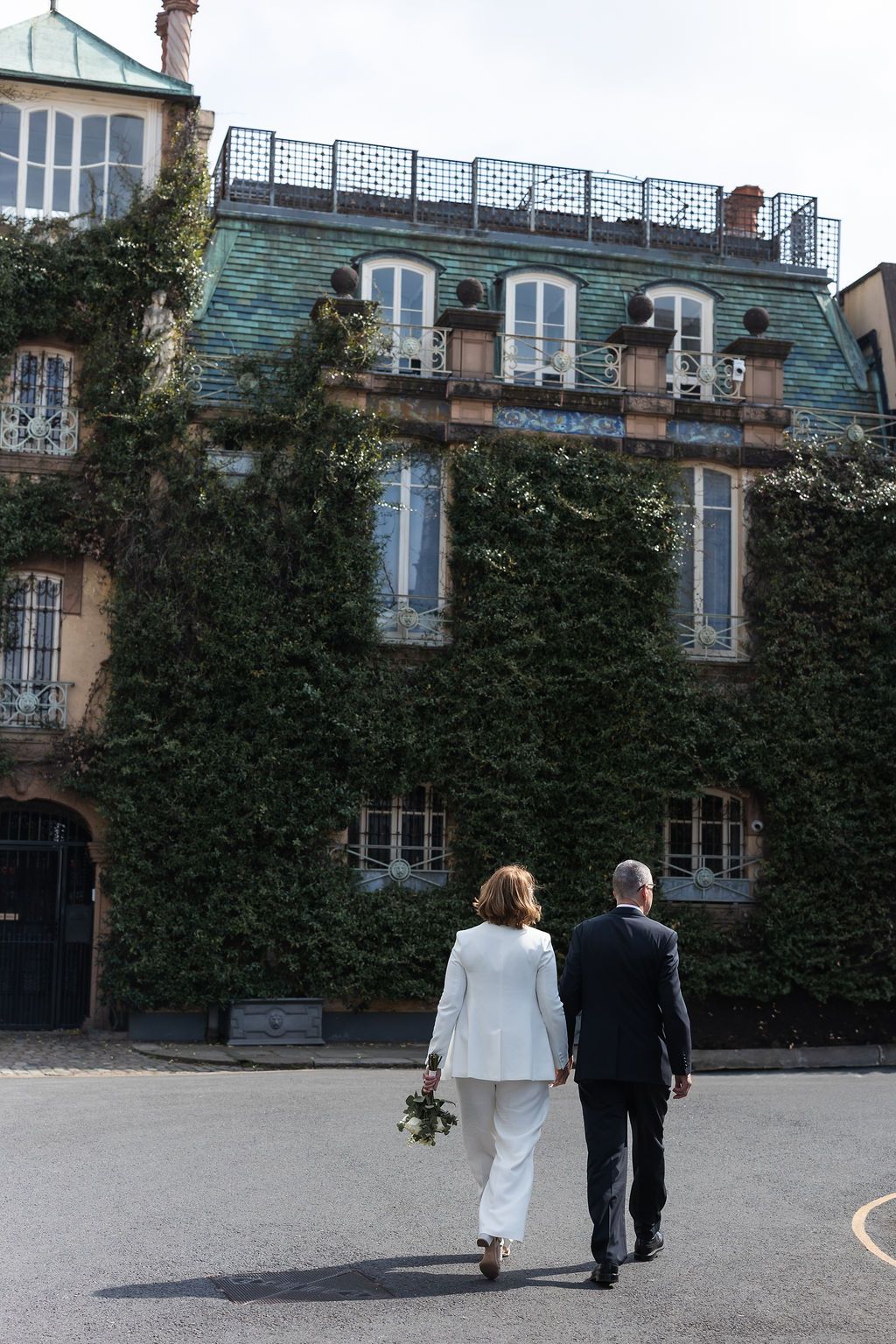 Bride and groom walking away from the camera, against the backdrop of beautiful houses in South Kensington, after London Town Hall wedding.
