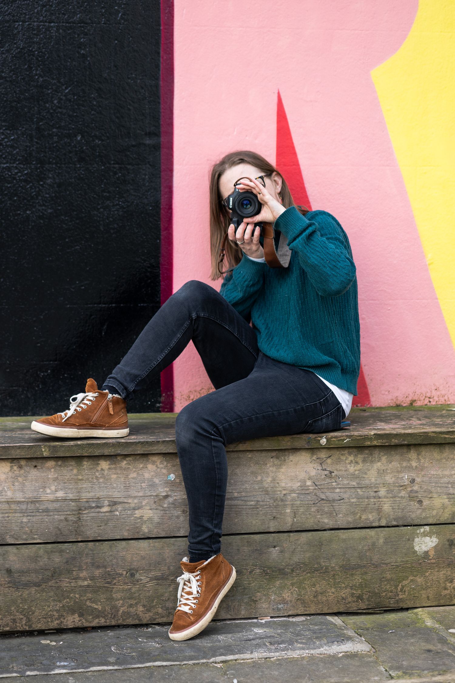 Personal branding headshot taken of a photographer, holding a camera up to their face.