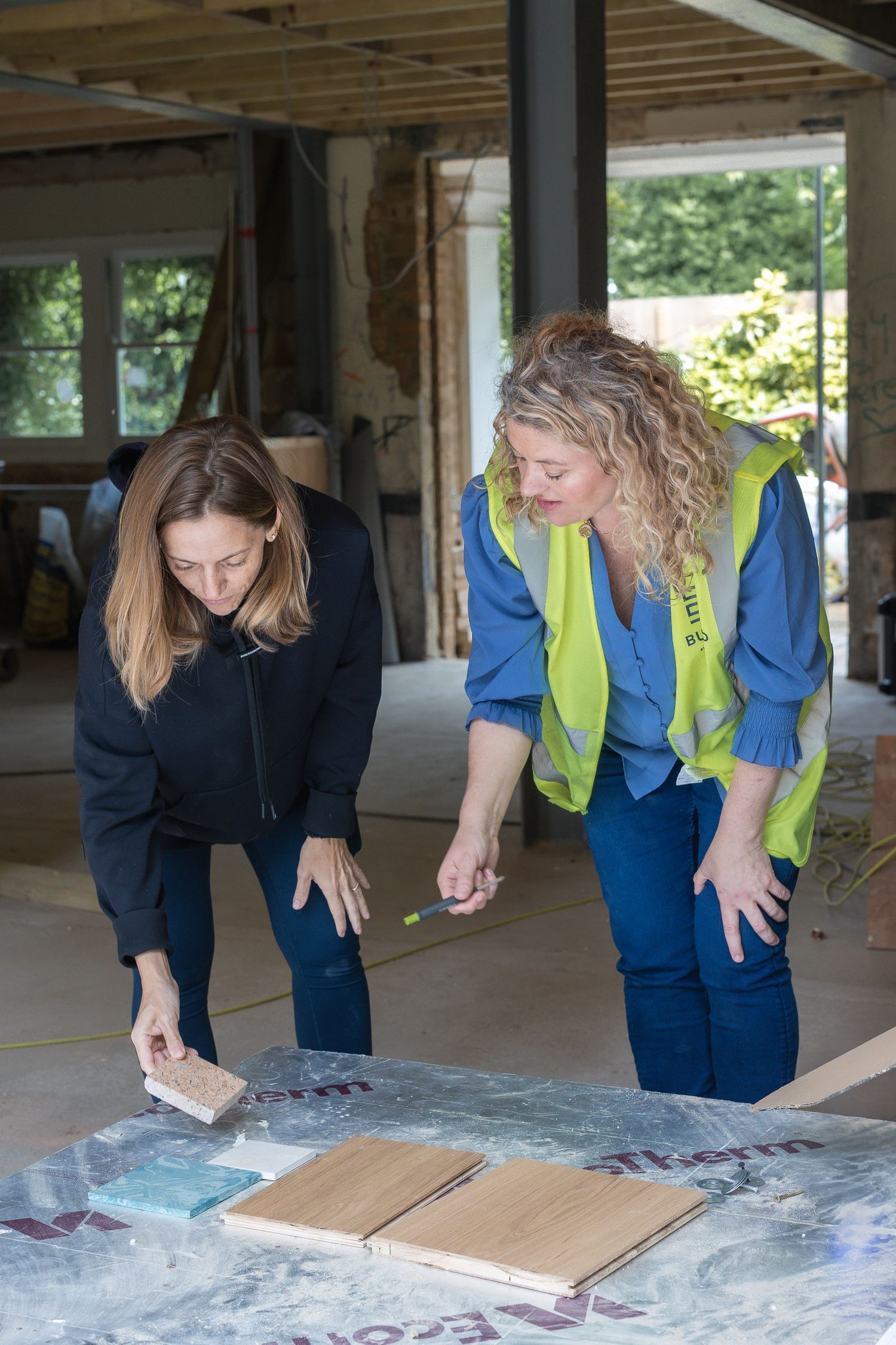 Female business owner, Charlie, chats to her client, in a behind the scenes photo of her construction business in St John's Wood, London.