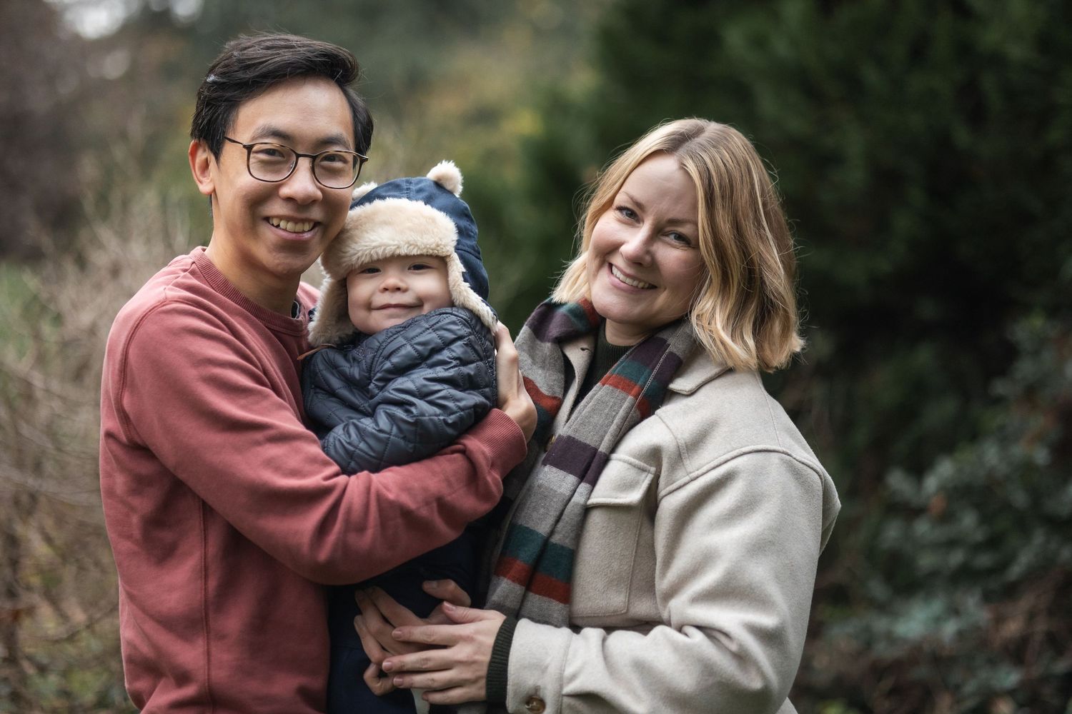 Mum and dad and their toddler bundled up in winter layers.