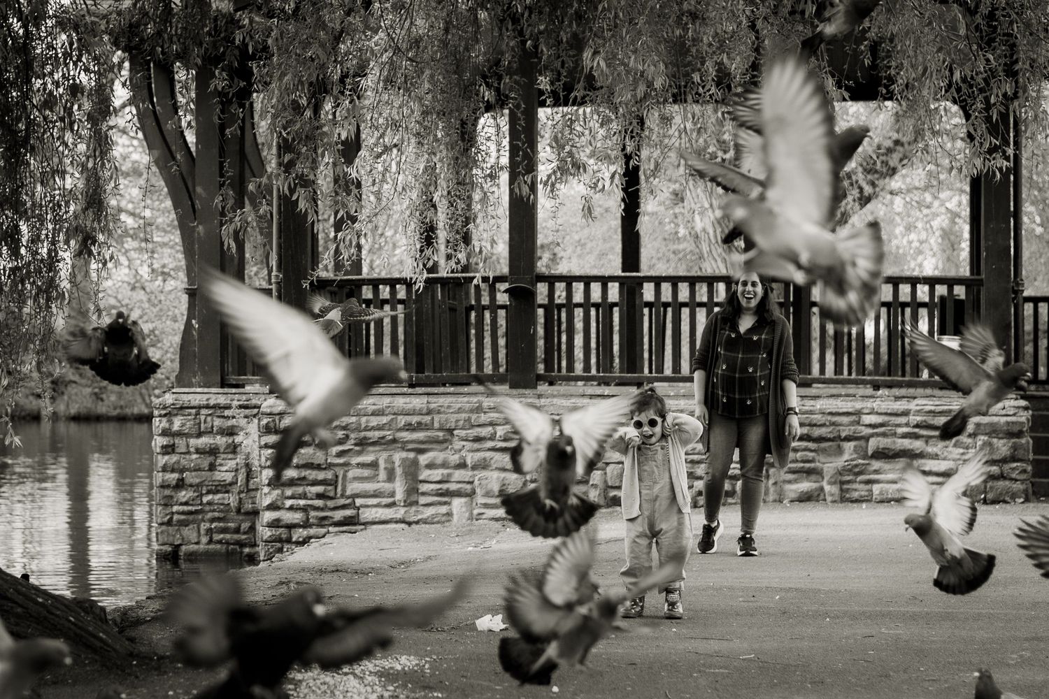 Bird flying and child running towards the camera in Broomfield park, North London.