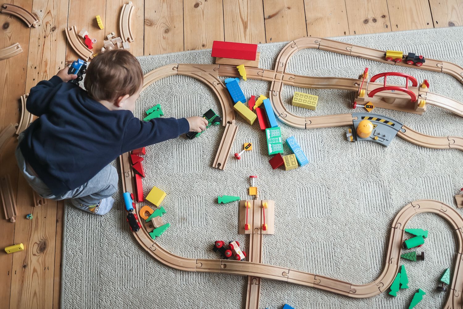 A young boy playing with his train set during an at home shoot.