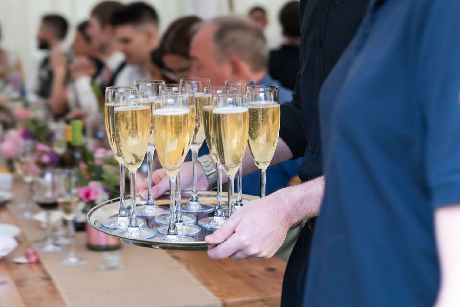 Champagne being carried out and delivered to the guests ahead of the wedding speeches.