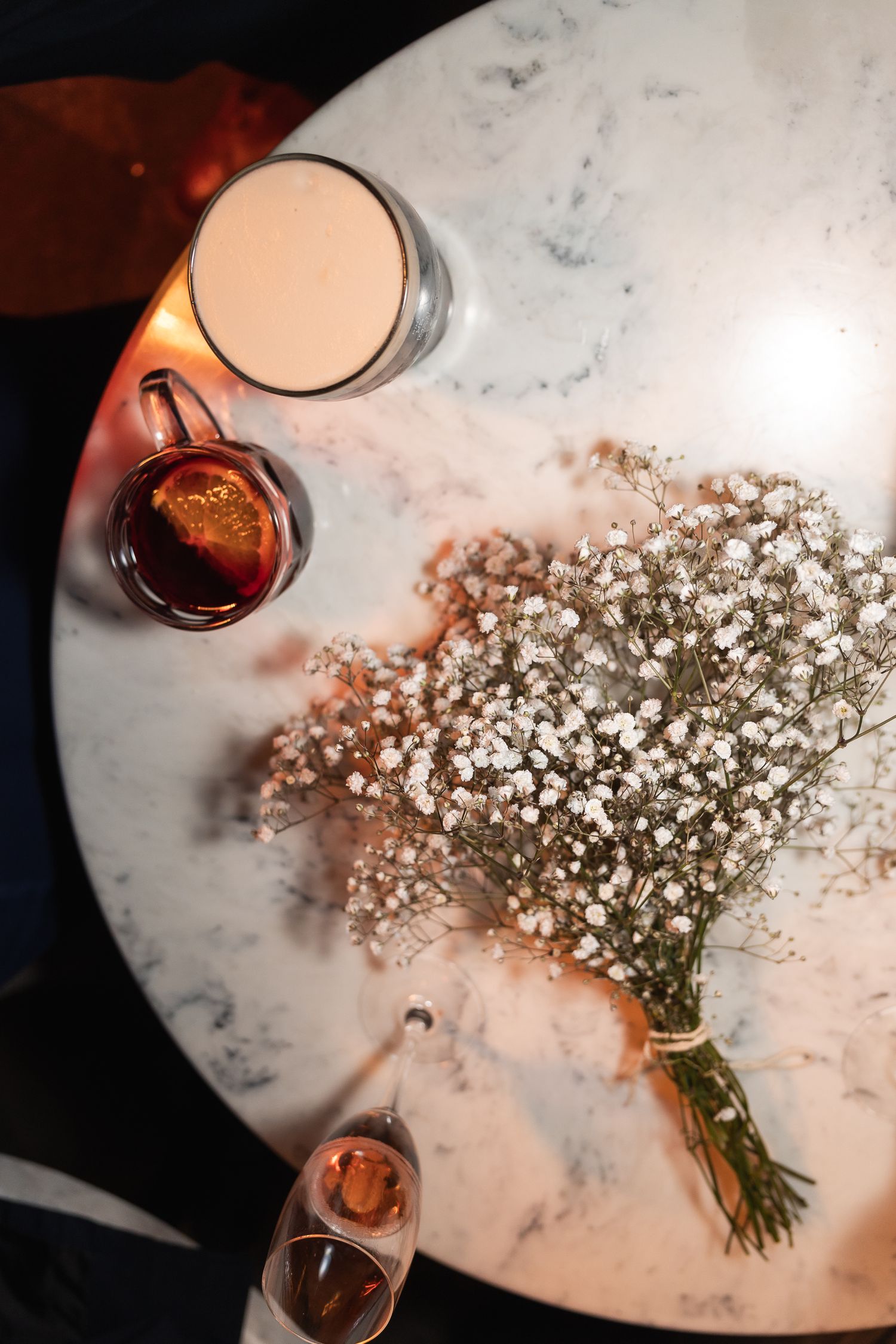 Flat lay image of bridal bouquet, champagne, beer and mulled wine, at the wedding reception of London Town Hall wedding.