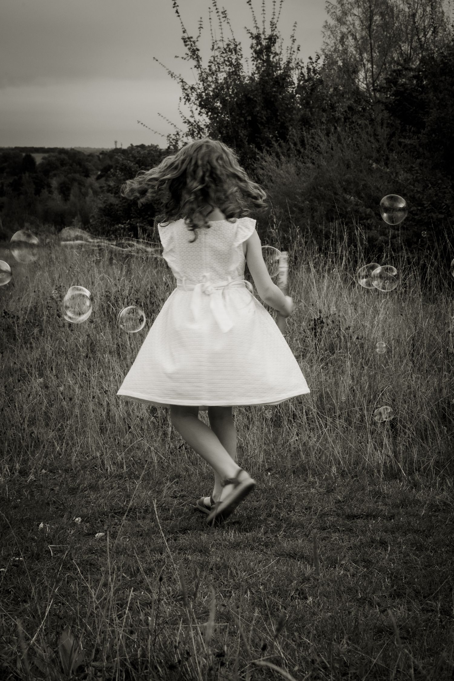 Photo of a girl playing with bubbles on relaxed family shoot in North London.
