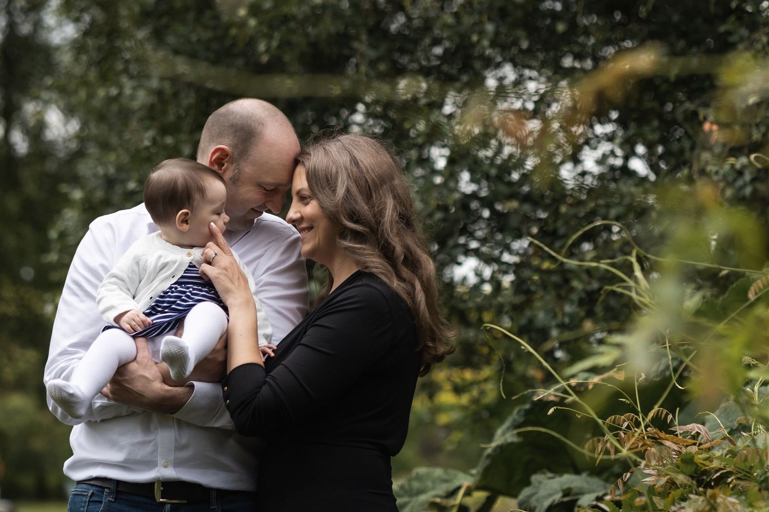 An intimate portrait of a mum, dad and their baby on an outdoor family photo session in Regents Park, central London.