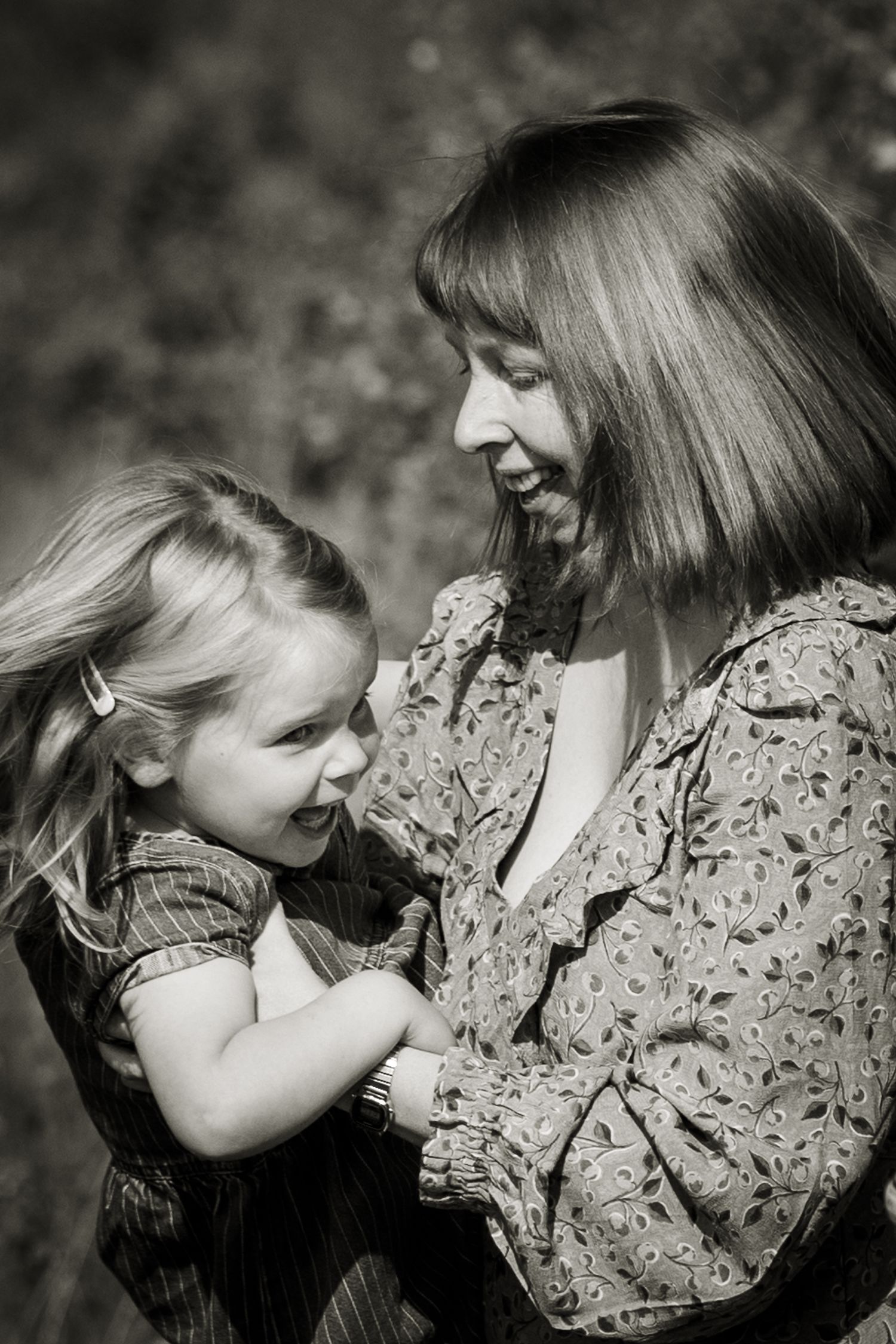 Black and white close up image of a mum spinning her daughter round on a family shoot in St Albans.