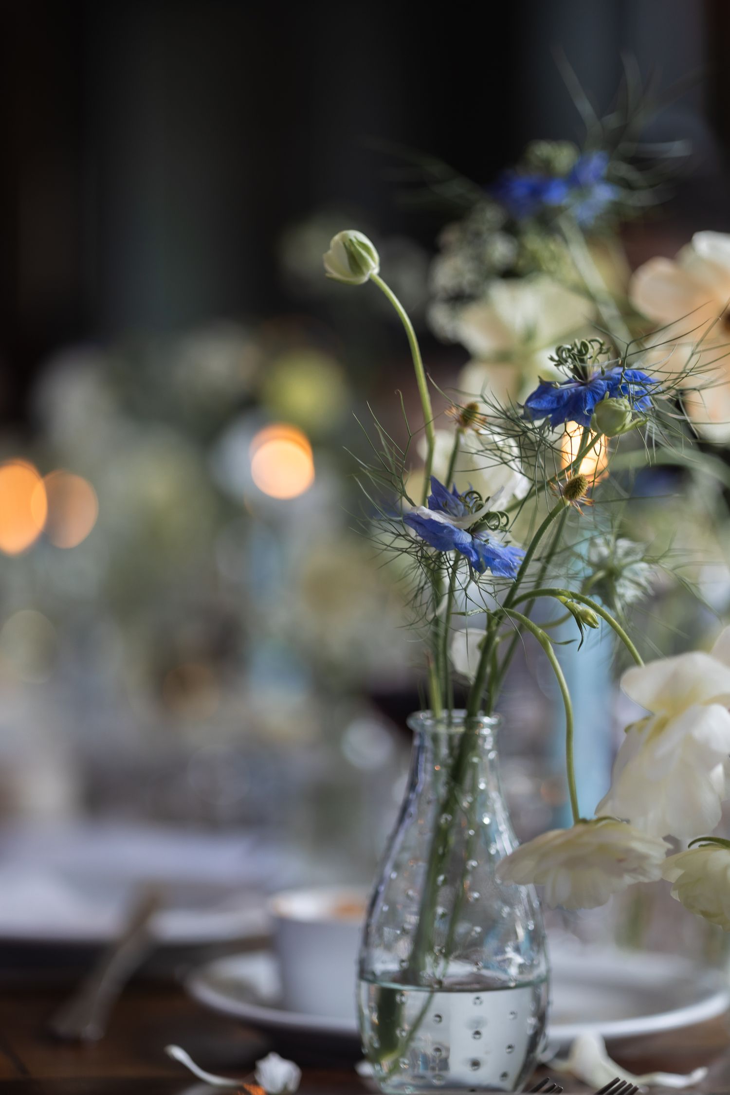 Close-up of wedding table decor with candles and floral details at London pub after christening ceremony.