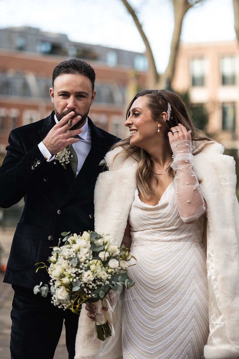 Groom smoking a traditional wedding cigar on the streets of London.
