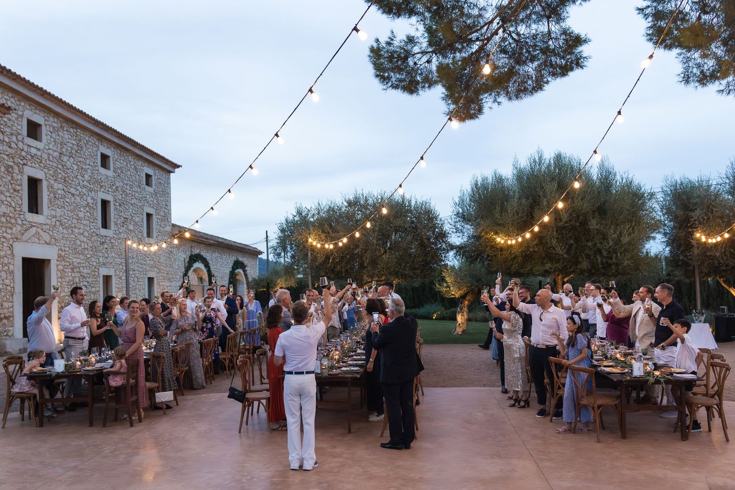 Raising a glass to the bride and groom during speeches at Finca Morneta in Mallorca, destination wedding.