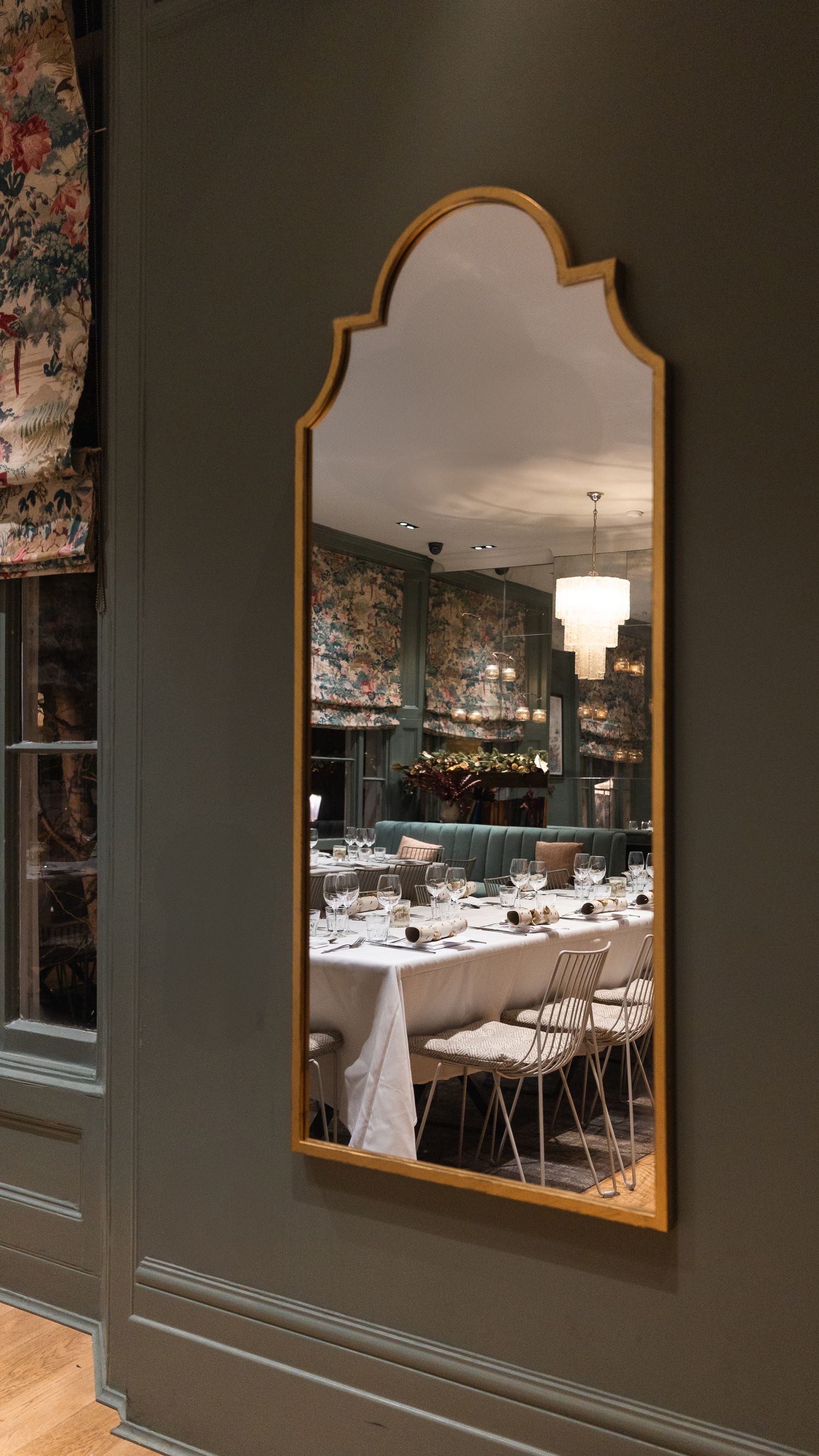Reflection in the mirror of wedding table with name places at The Phene, London.
