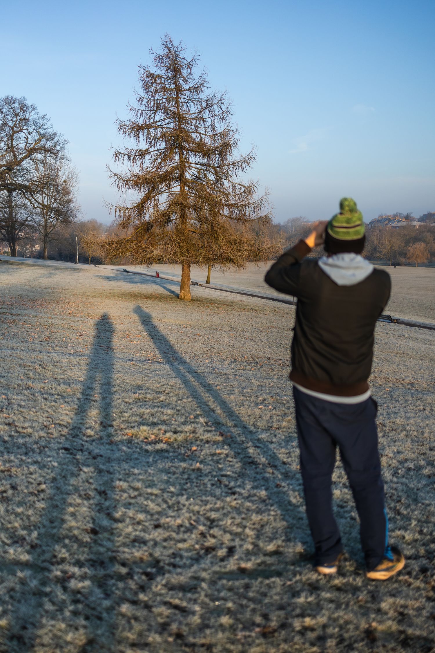 Photo plus shadow (and also my shadow) of my husband taking a photo of a frosty scene.