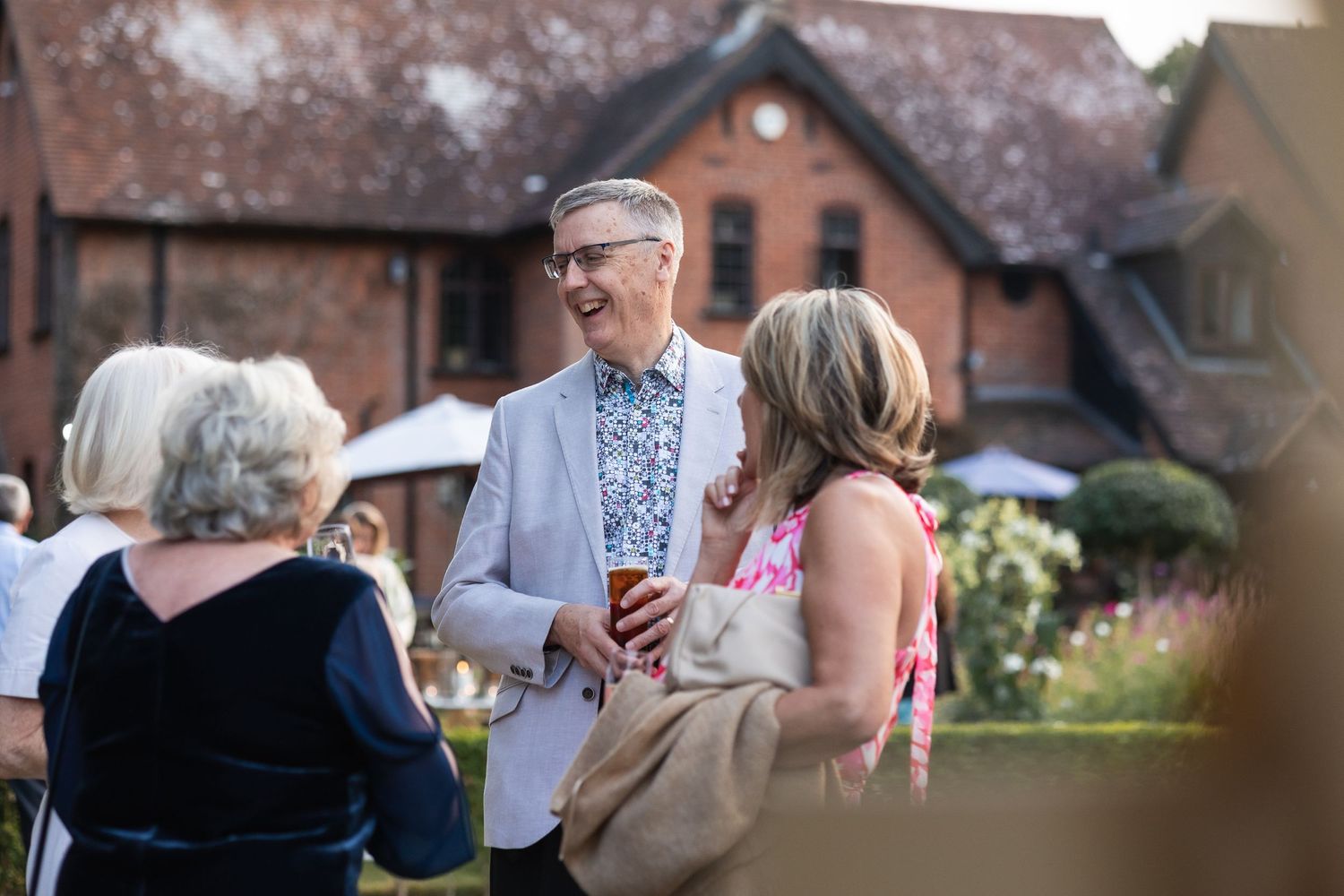 Guests chatting and enjoying themselves in the garden at an at-home wedding reception in Ware.