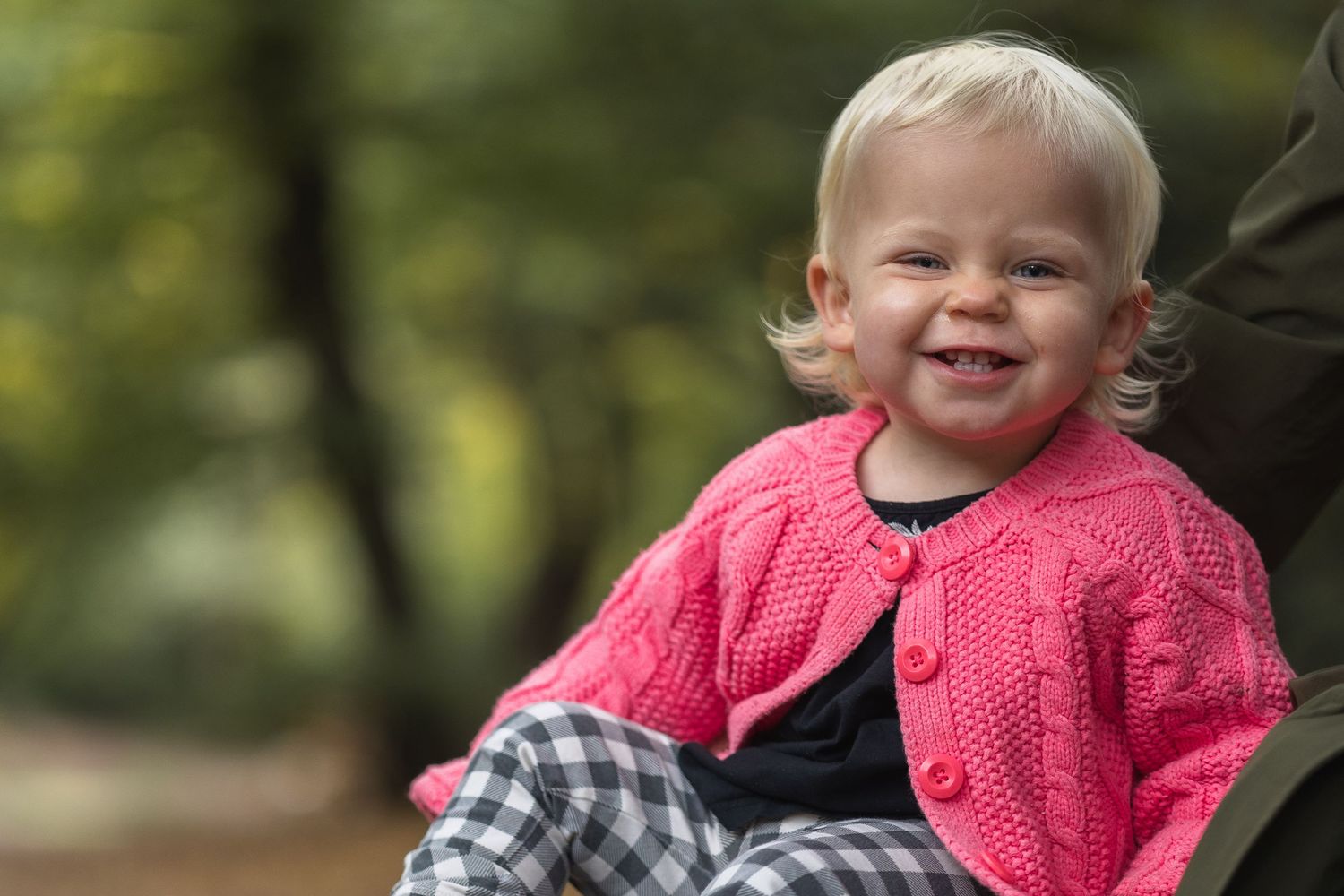 Close up image of toddler with a cheeky grin looking at the camera.