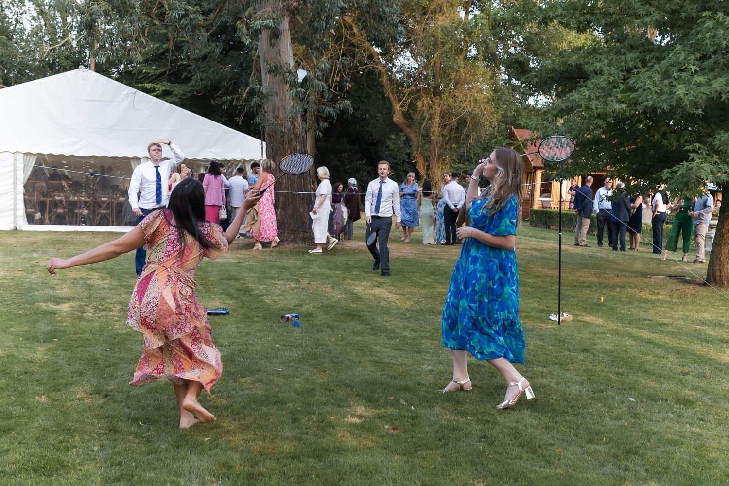 Garden games including badminton, infront of the marquee, at summer wedding in Hertfordshire.