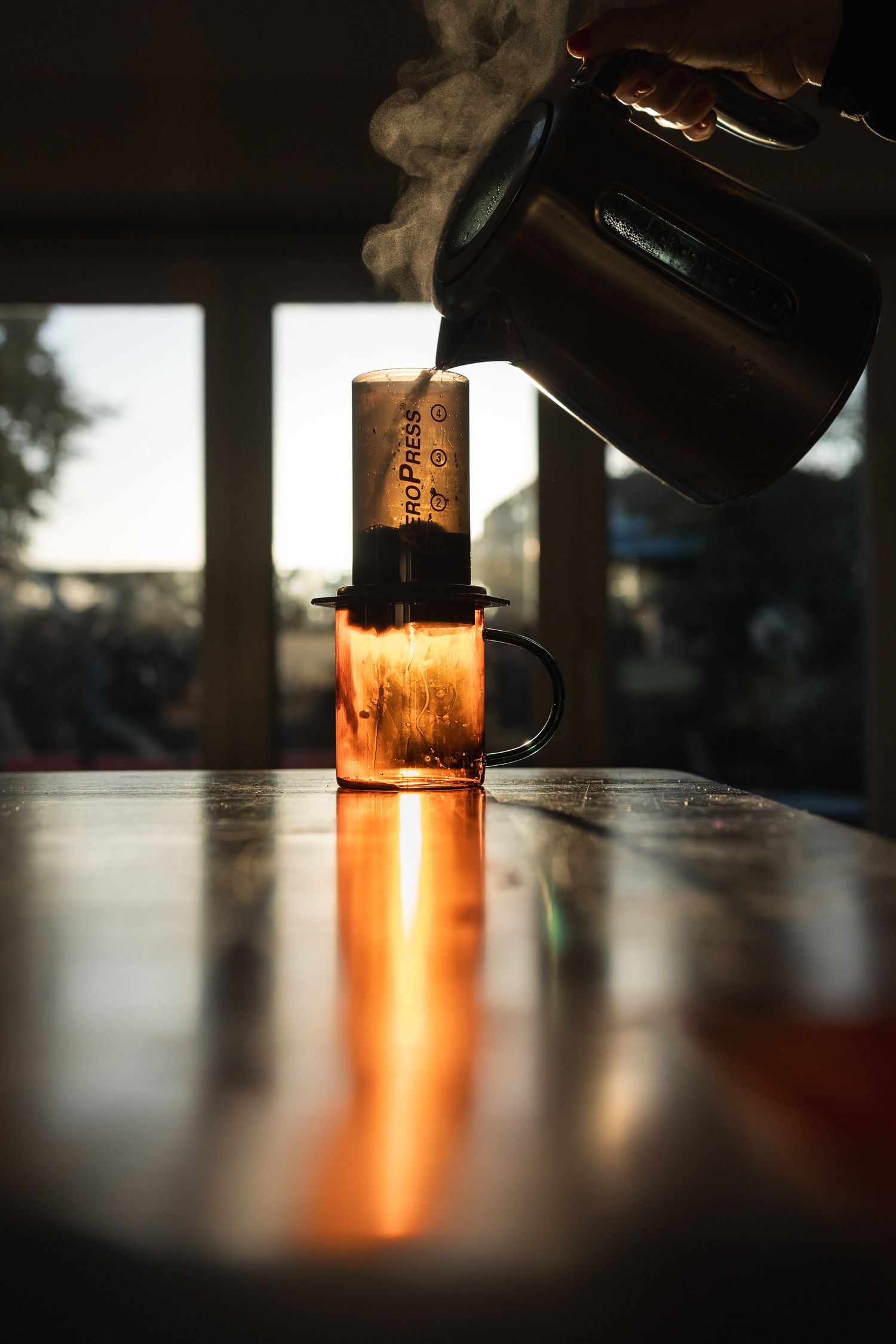 The soft daylight illuminating the simple act of making a cup of coffee in the aeropress,