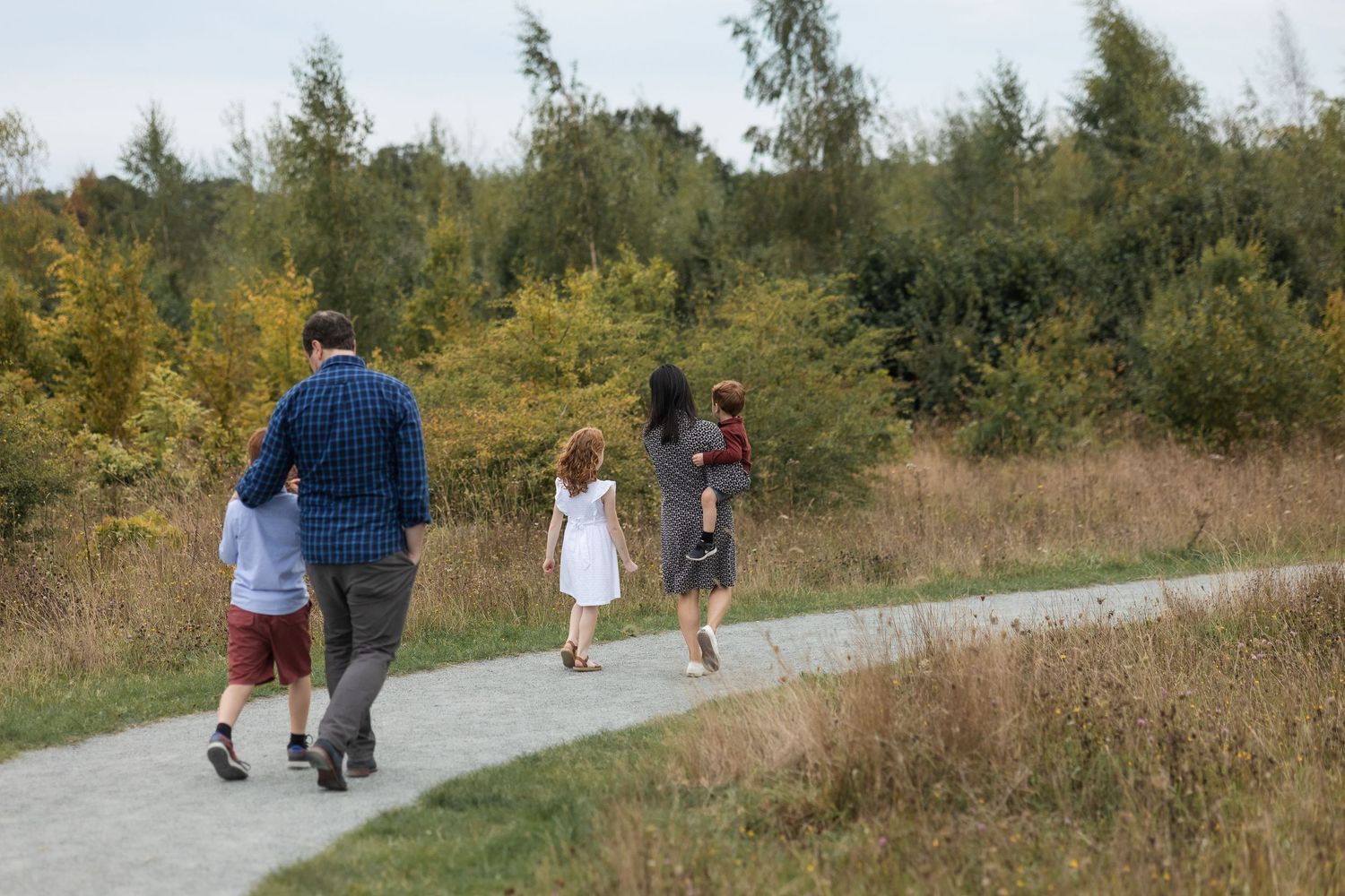 A lovely family of 5 walking away from the camera during an Autumn family photo shoot in Hertfordshire.