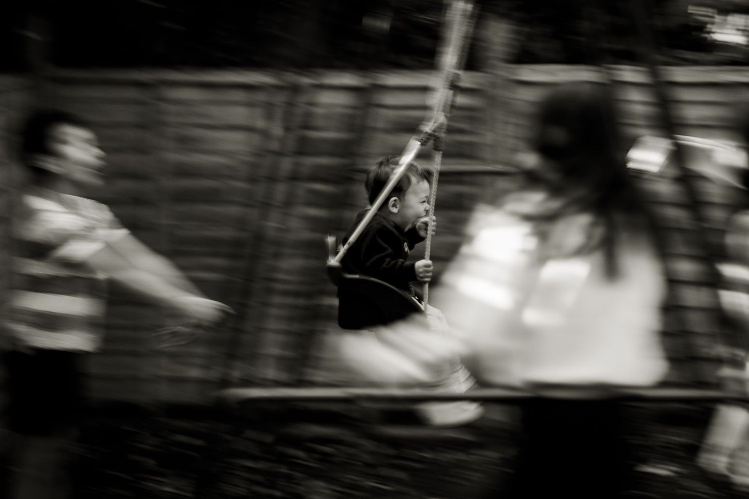 Siblings playing in the garden. Panning on youngest child in the swing to depict movement.