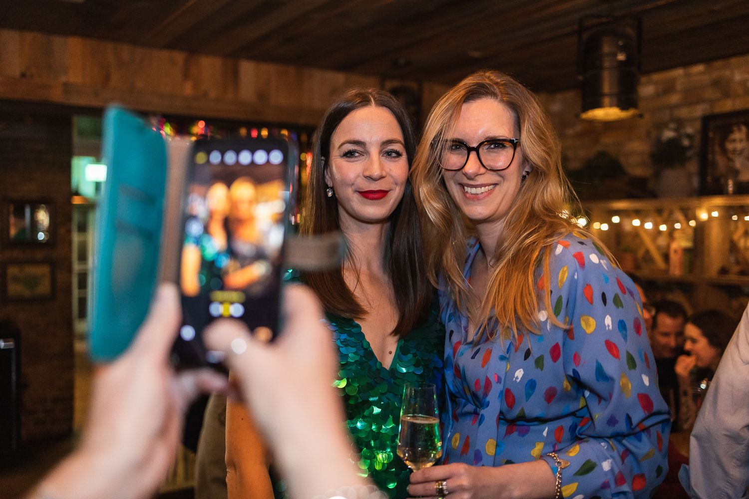A photo of someone taking a photo of the birthday girl and her sister.